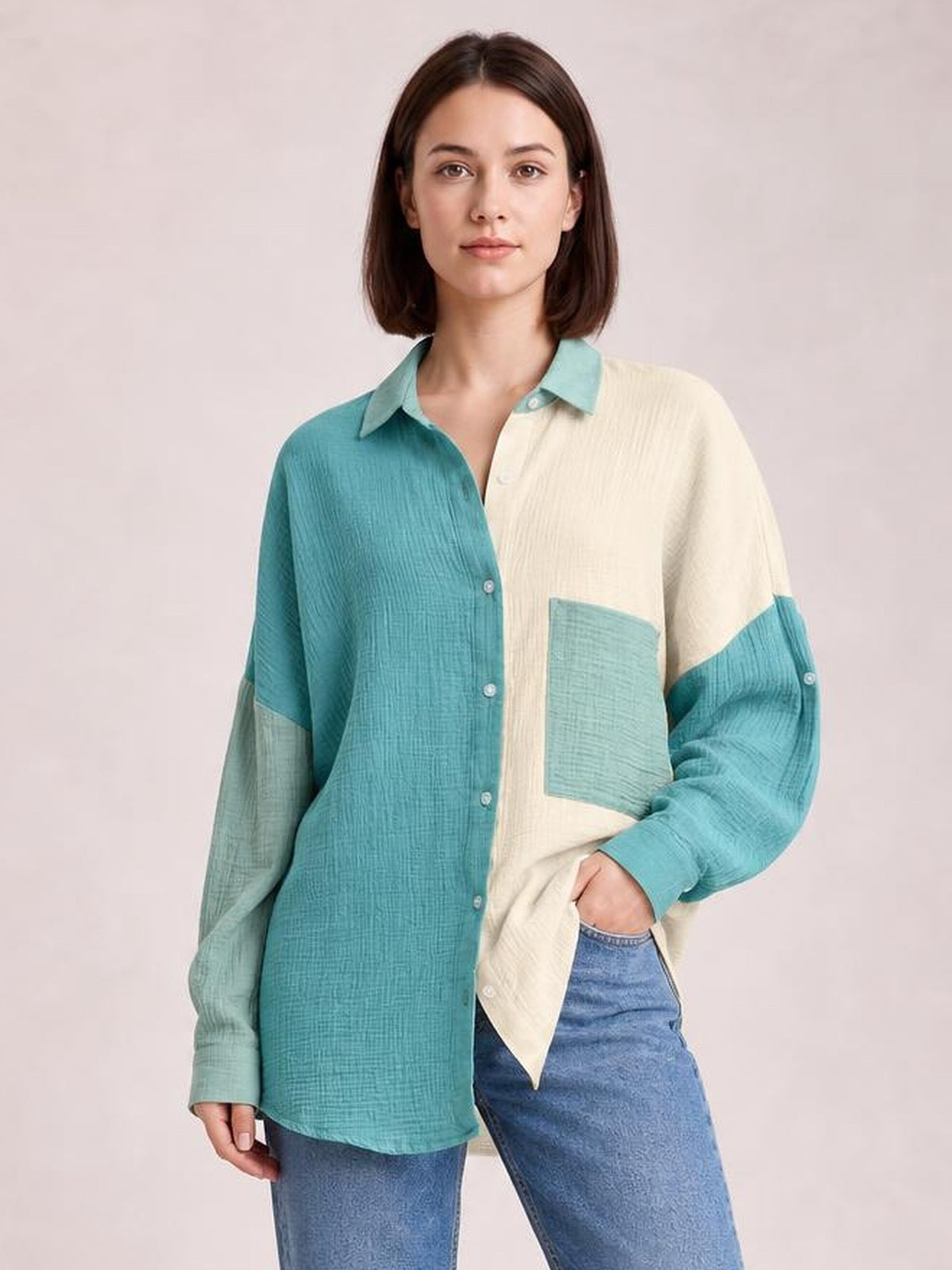 Model poses in a relaxed, long-sleeve textured button-up shirt with a collared neckline, teal-and-cream color blocking, button front, and chest pocket.