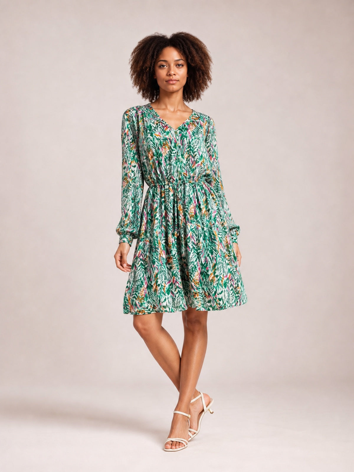 Model poses in a green botanical-print long-sleeve dress with a V-neck, ruched drawstring waist, buttoned front, and gently flared skirt.