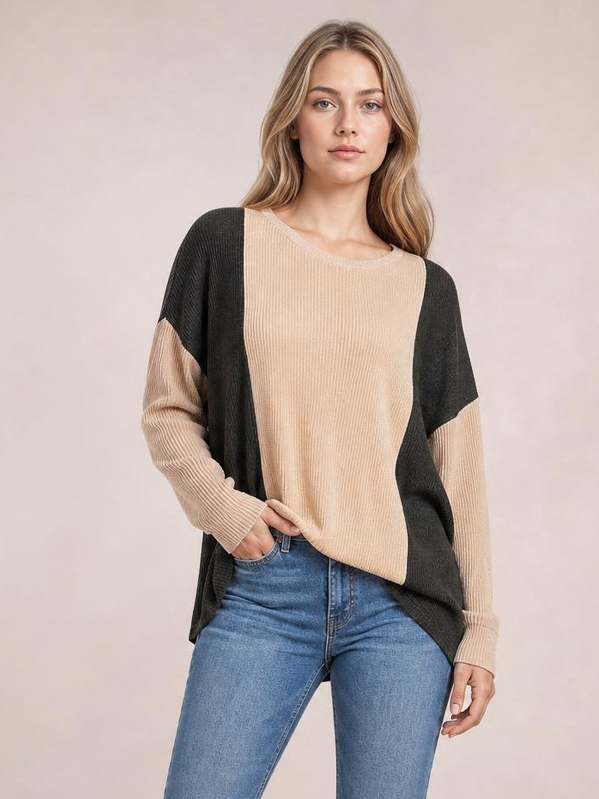 Model poses in a beige and black texture contrast round neck long sleeve T-shirt with ribbed construction and a relaxed, curved hem.