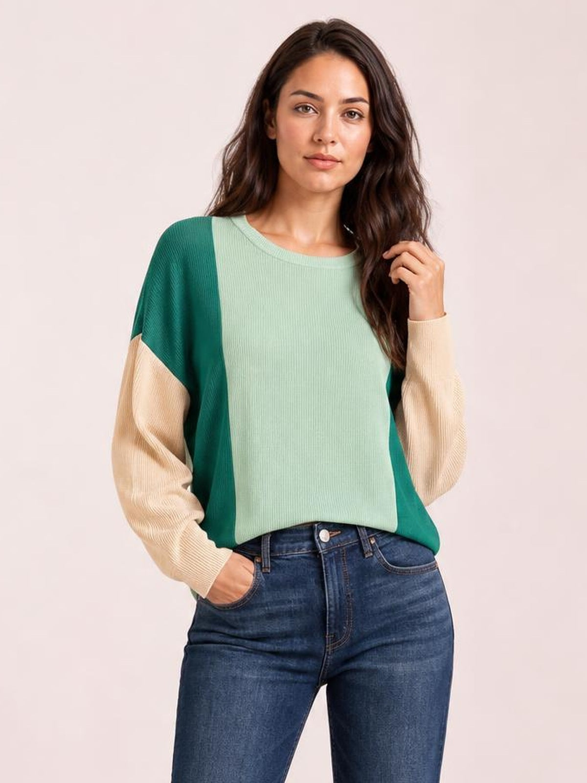 Model poses in a textured color-block long sleeve T-shirt with a round neck, mint green front, teal side panels, and beige sleeves.