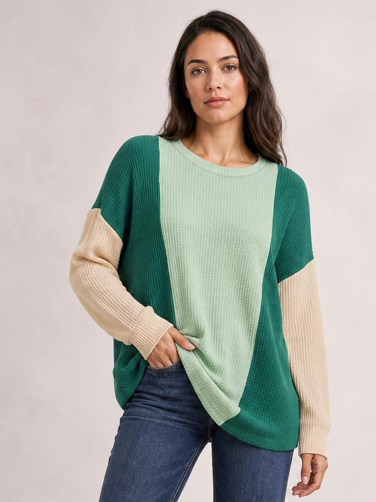 Model wearing a textured contrast round-neck long-sleeve T-shirt with a mint green front, dark green panels, beige sleeves, and a relaxed silhouette.