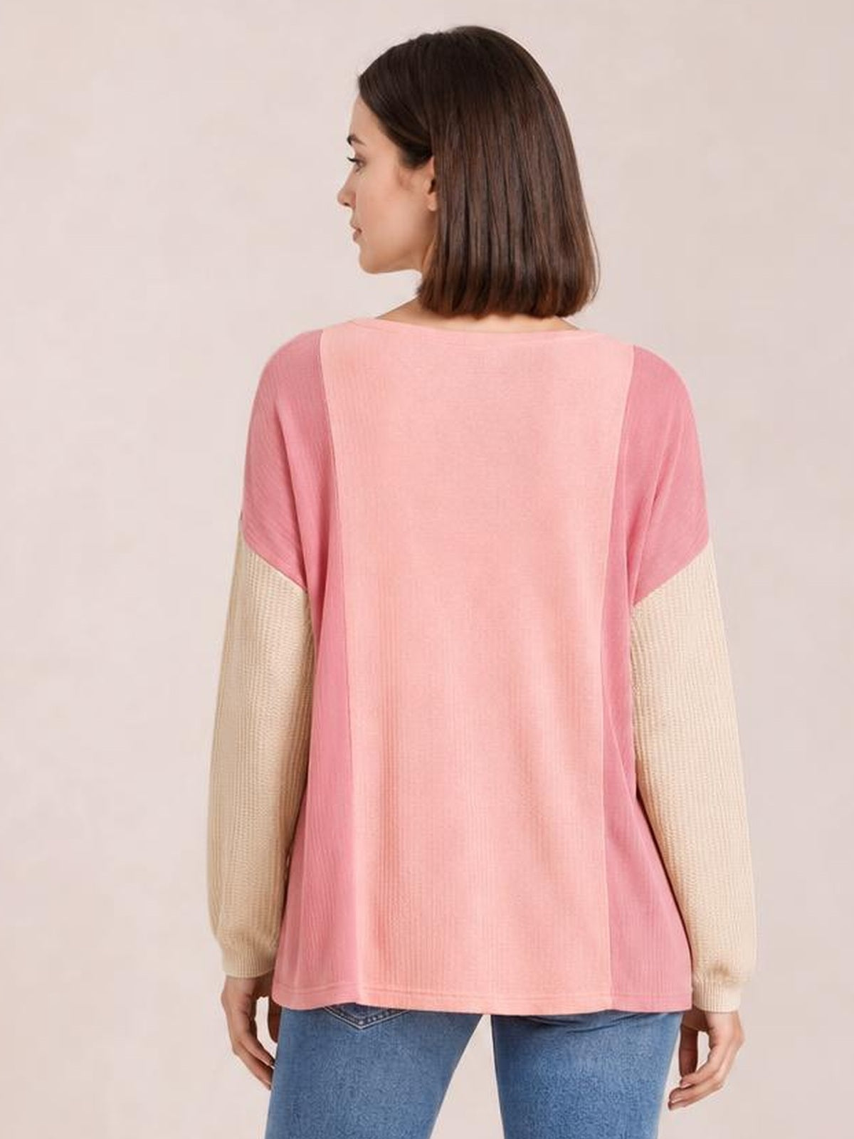 Model shown from the back wearing a pink round-neck long-sleeve T-shirt with contrasting cream textured sleeves and a relaxed straight silhouette.