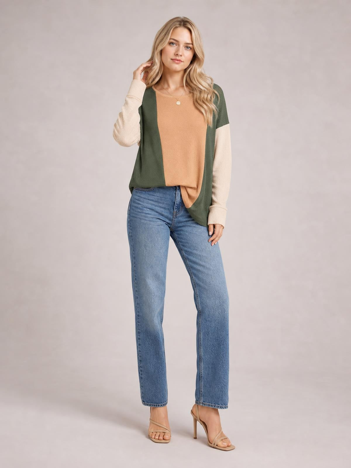 Model poses in a textured contrast round-neck long-sleeve T-shirt with an olive green, tan, and cream color-block design and relaxed silhouette.