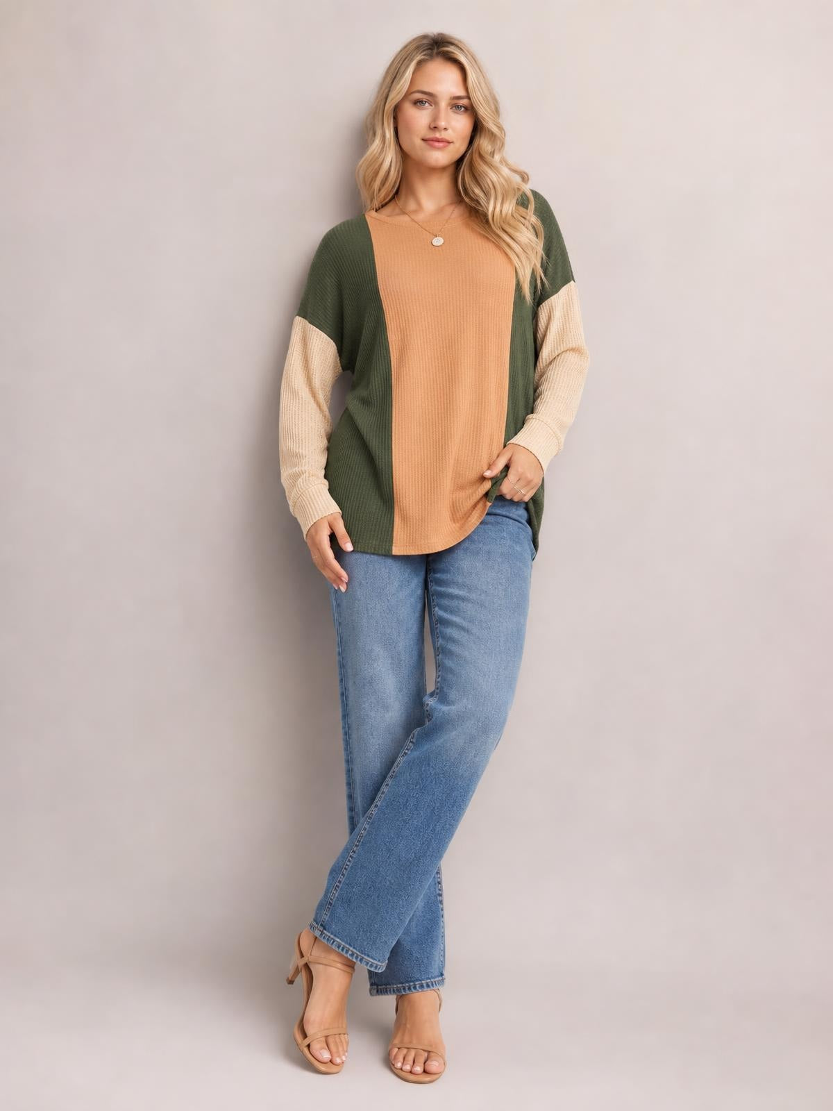 A model poses in a relaxed texture contrast round neck long sleeve T-shirt with an olive green and camel color-blocked relaxed silhouette.