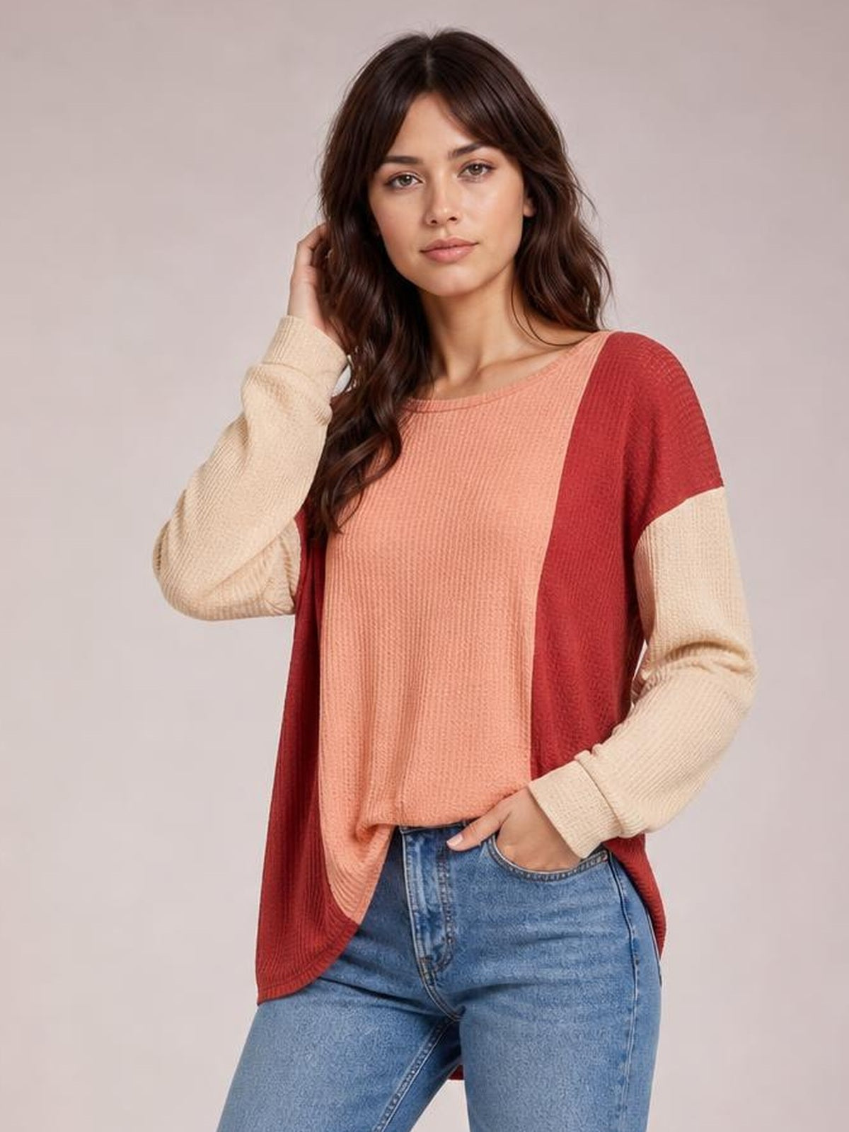 Model wearing a textured contrast round-neck long-sleeve T-shirt with a coral front, burgundy side panels, cream sleeves, and a relaxed silhouette.