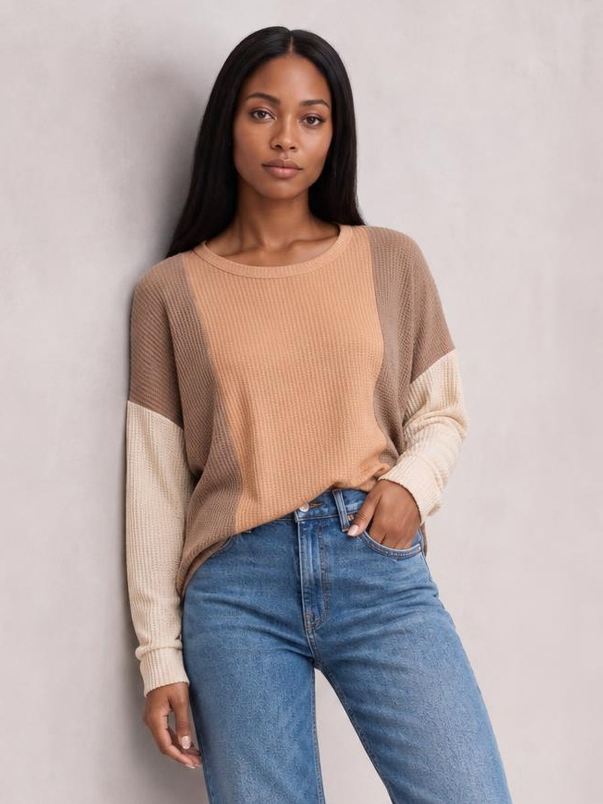 Model wears a tan textured contrast round-neck long-sleeve T-shirt with cream sleeves, a relaxed silhouette, and ribbed construction.