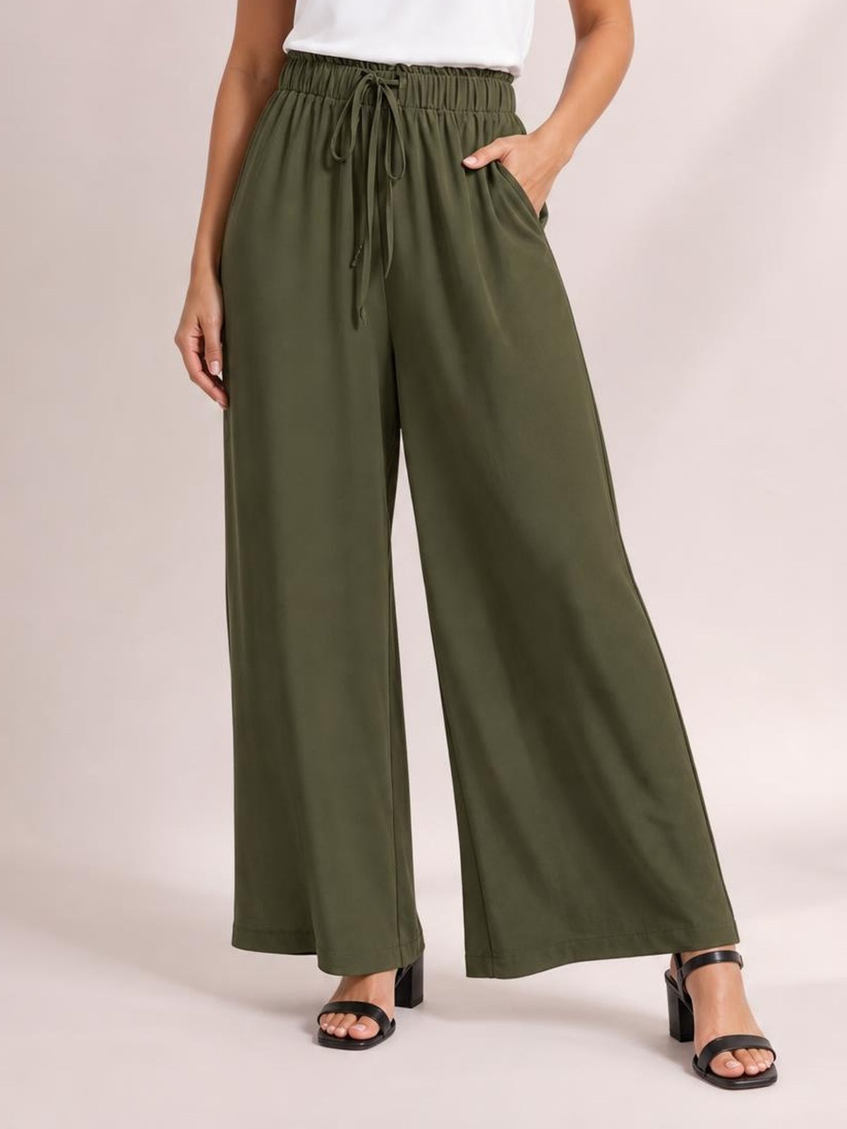 Model wearing olive green drawstring wide-leg pants with an elastic waistband, front tie, relaxed silhouette, and side pockets.