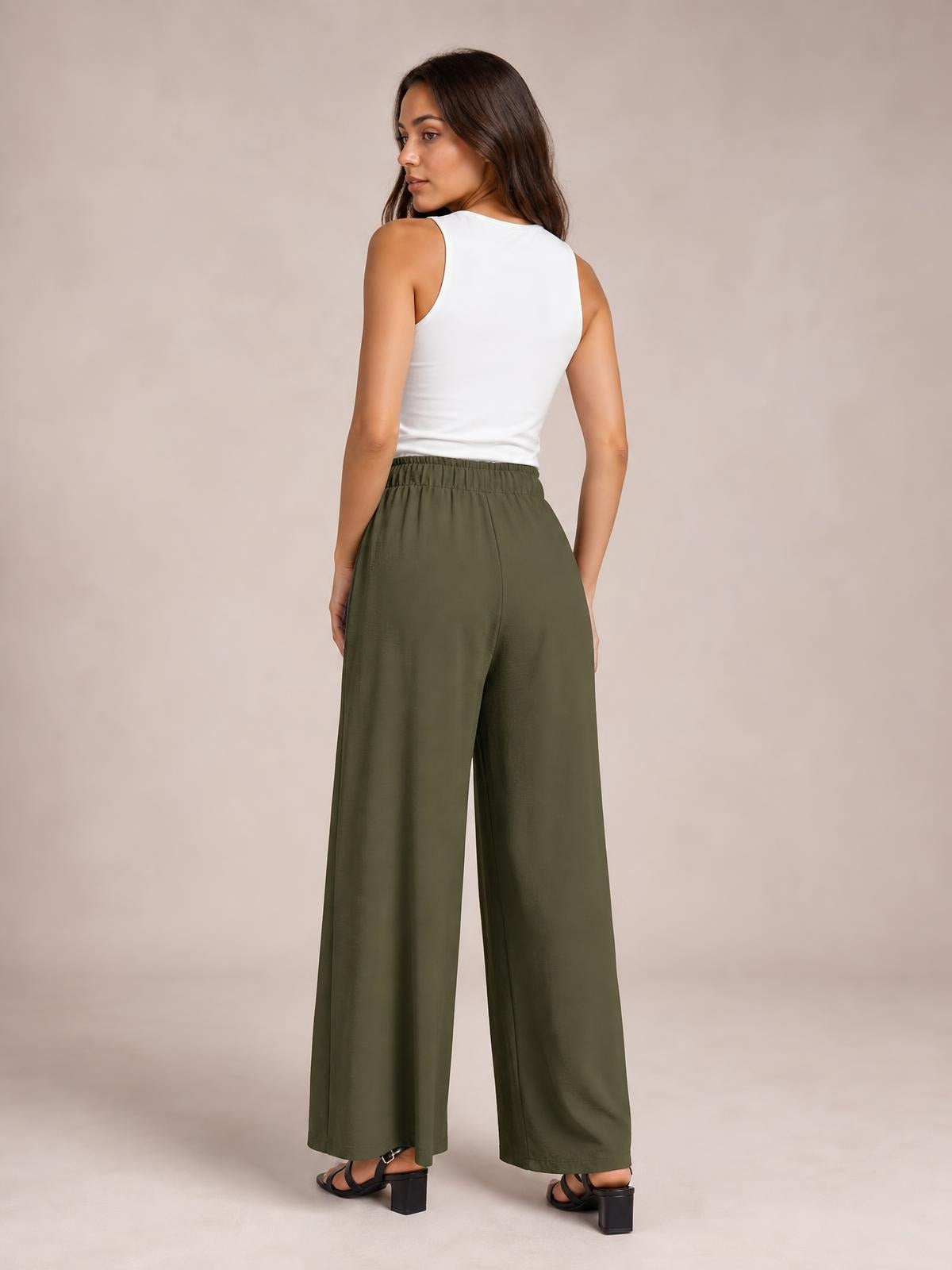 A model looks over her shoulder while wearing olive-green wide-leg pants with an elasticized waistband and full-length, relaxed drape.