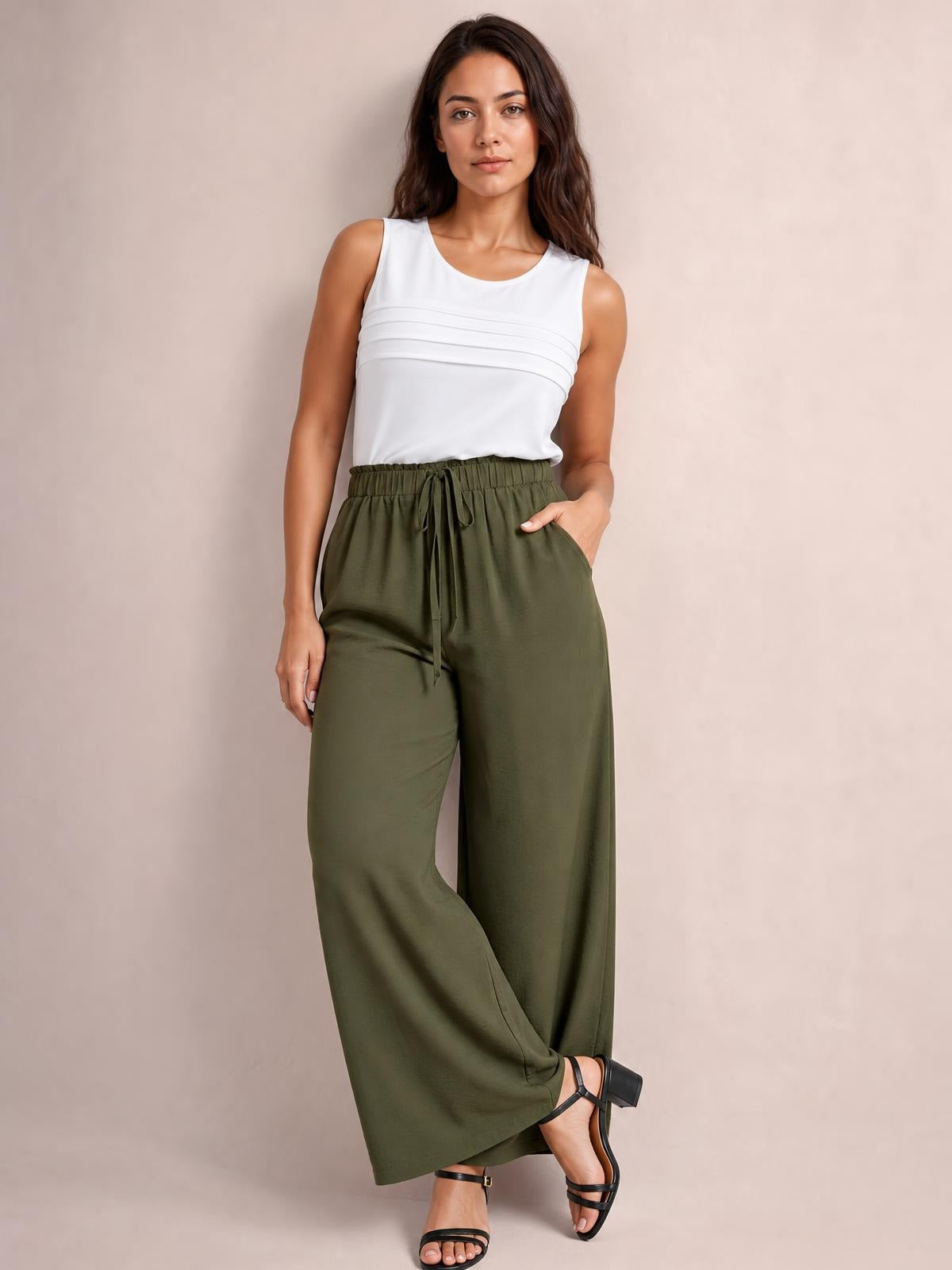 Model poses in olive green drawstring wide-leg pants with an elastic waistband, front tie, relaxed flowing silhouette, and side pockets.