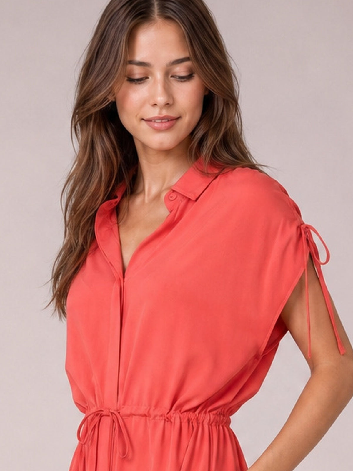 Model poses in a coral drawstring collared neck midi dress with short sleeves, buttoned front, gathered waist, and softly flared silhouette.