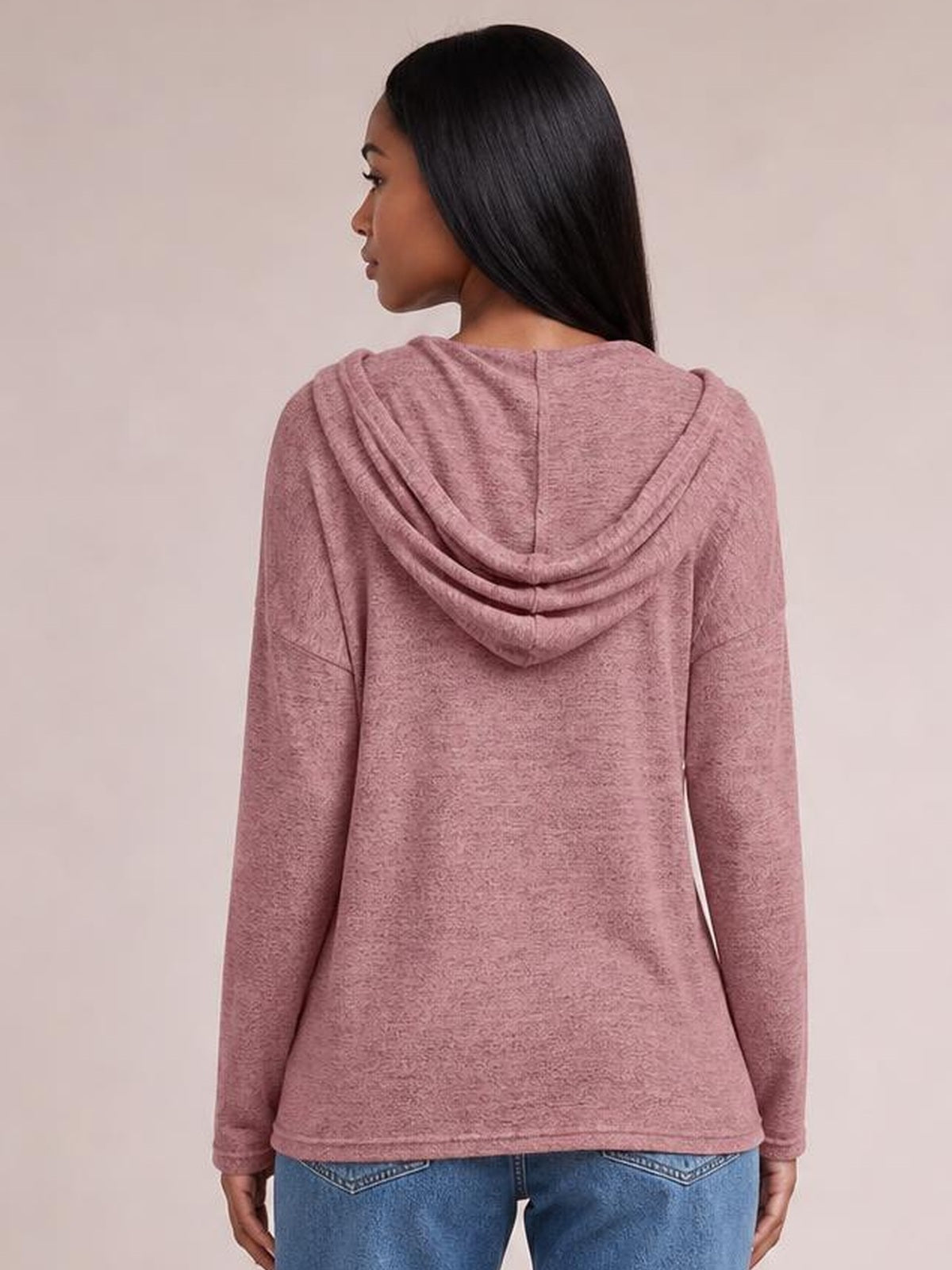 Model shown from the back wearing a dusty rose drawstring hooded T-shirt with dropped shoulders, long sleeves, and a relaxed straight silhouette.