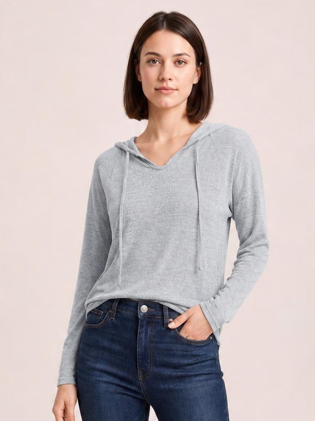 Model wears a light gray drawstring hooded T-shirt with dropped shoulders, long sleeves, a relaxed silhouette, and a slightly curved hem.
