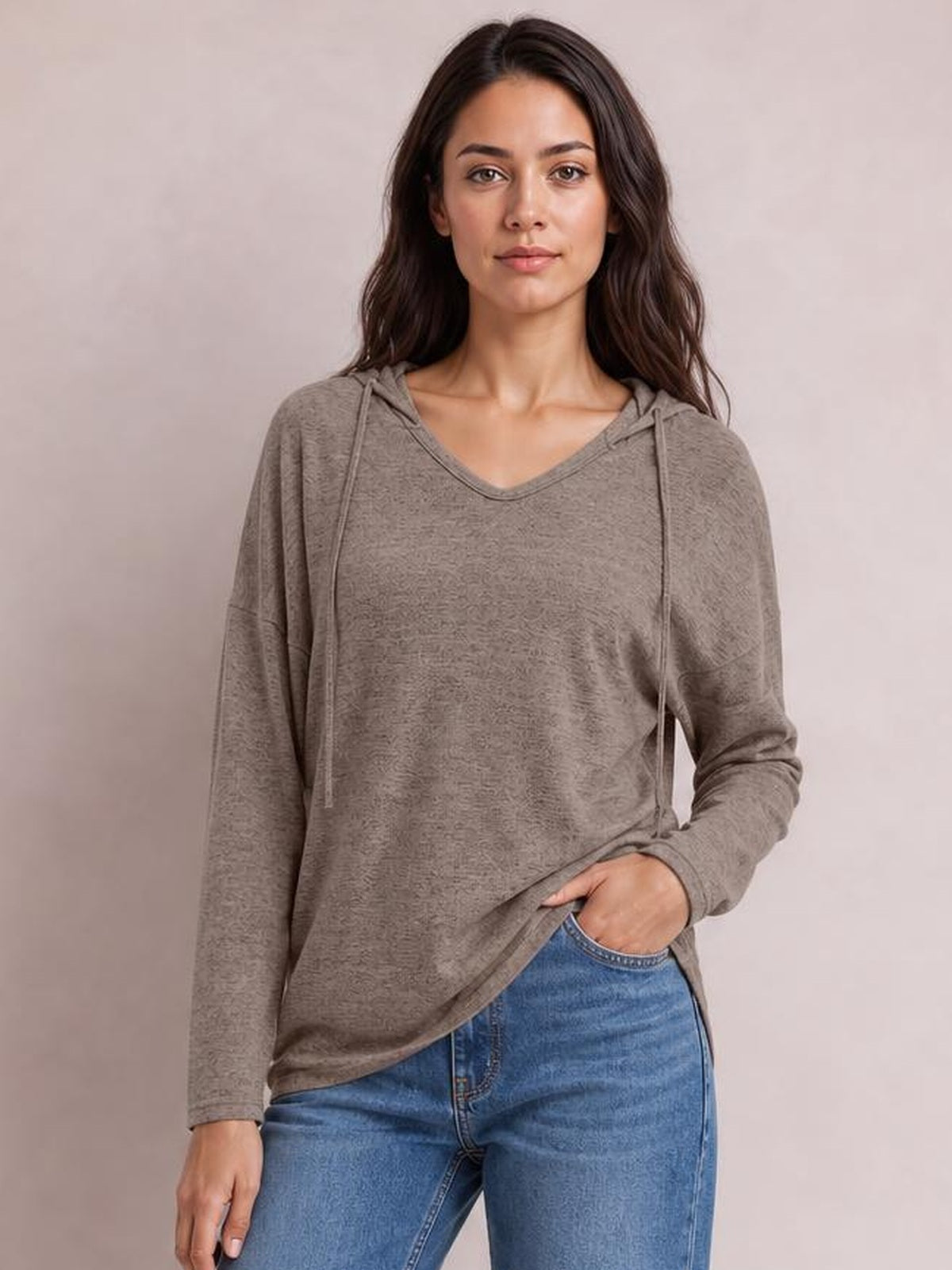 Model wearing a taupe drawstring dropped-shoulder hooded T-shirt with a relaxed silhouette, long sleeves, and V-neck hood detail.