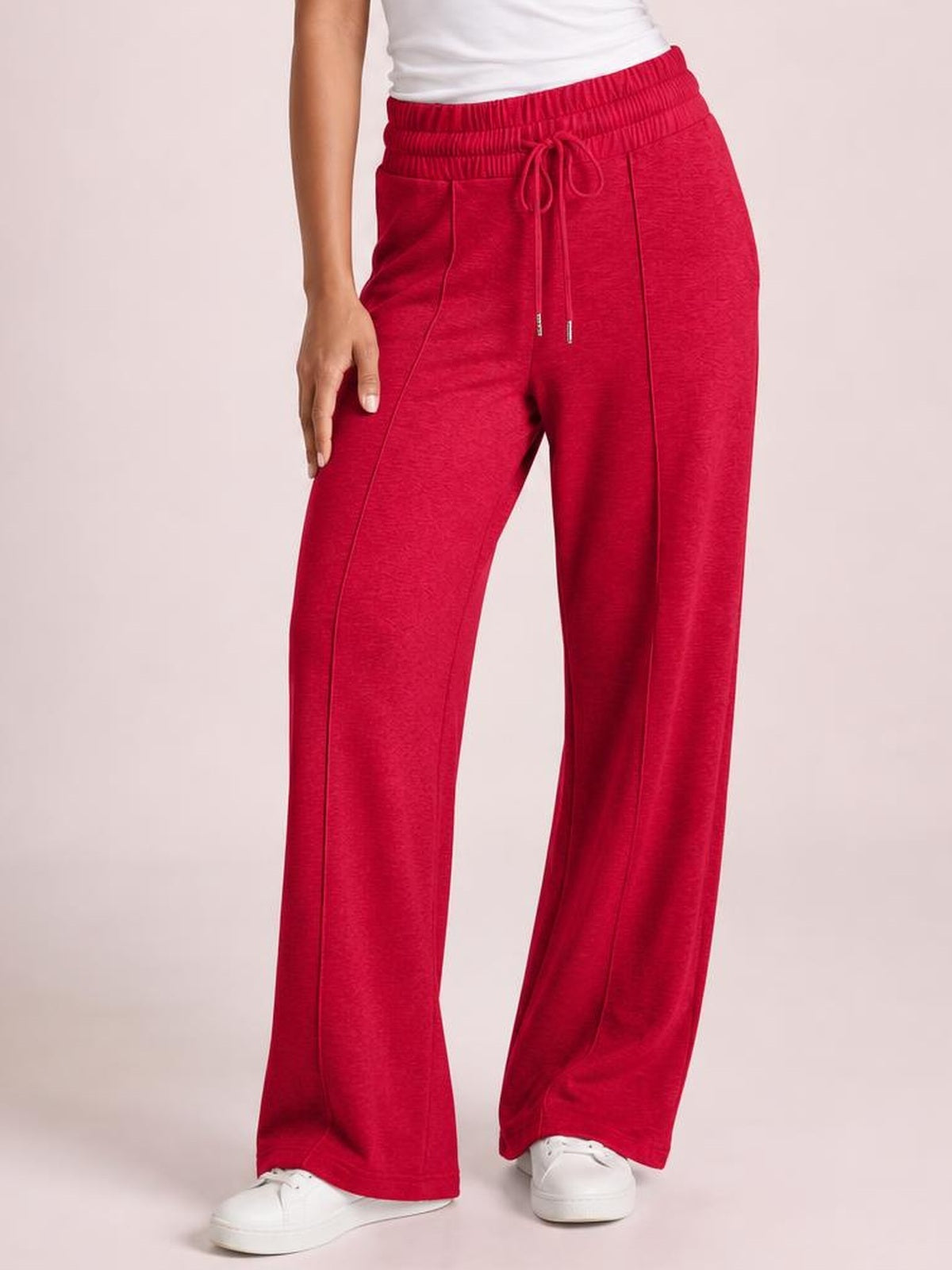Model wearing bright red drawstring elastic waist wide leg pants with front pockets, relaxed straight silhouette, and visible seam details.