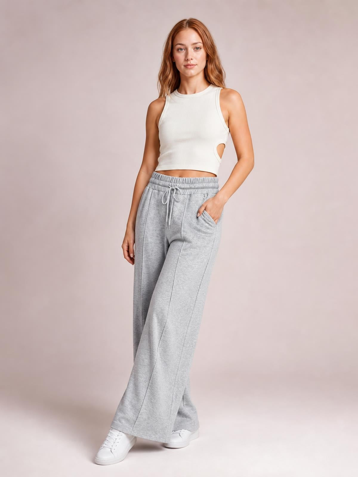 Model poses in light gray drawstring elastic-waist wide-leg pants with a relaxed flowing silhouette, seamed construction, and side pockets.