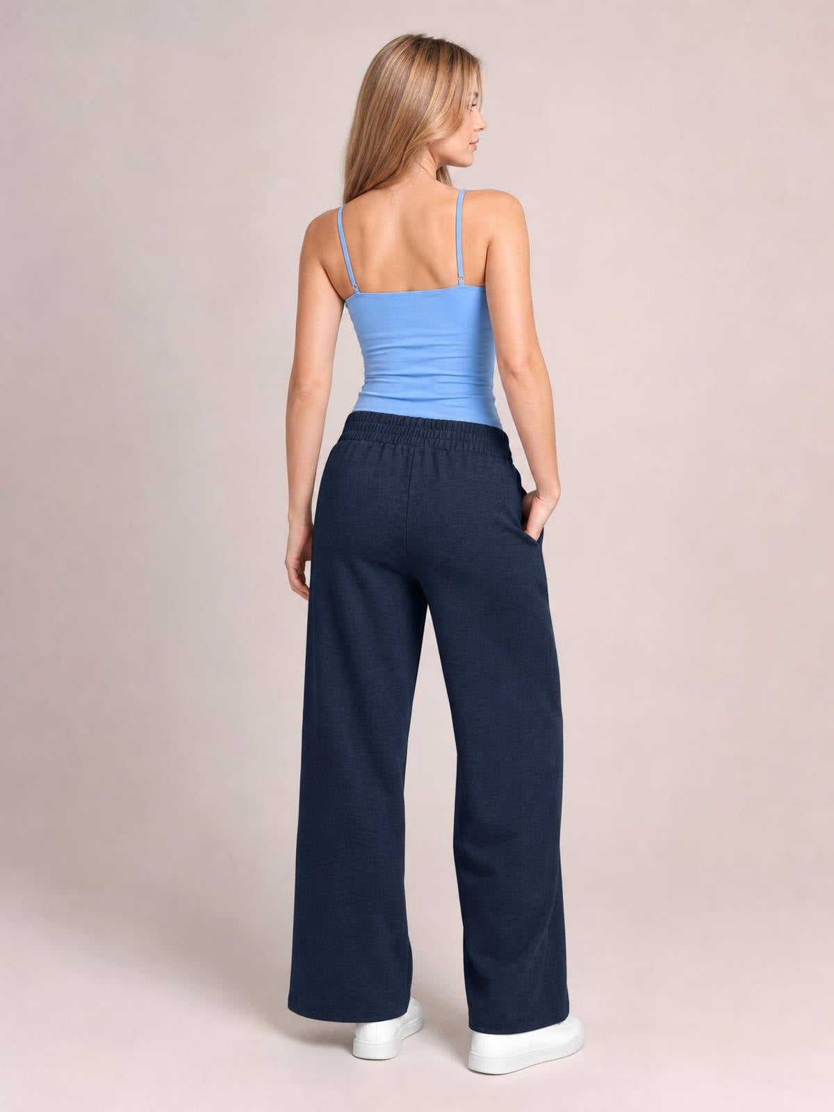 Model turned away showcases navy drawstring elastic waist wide leg pants with a relaxed silhouette, side pockets, and full-length hems.