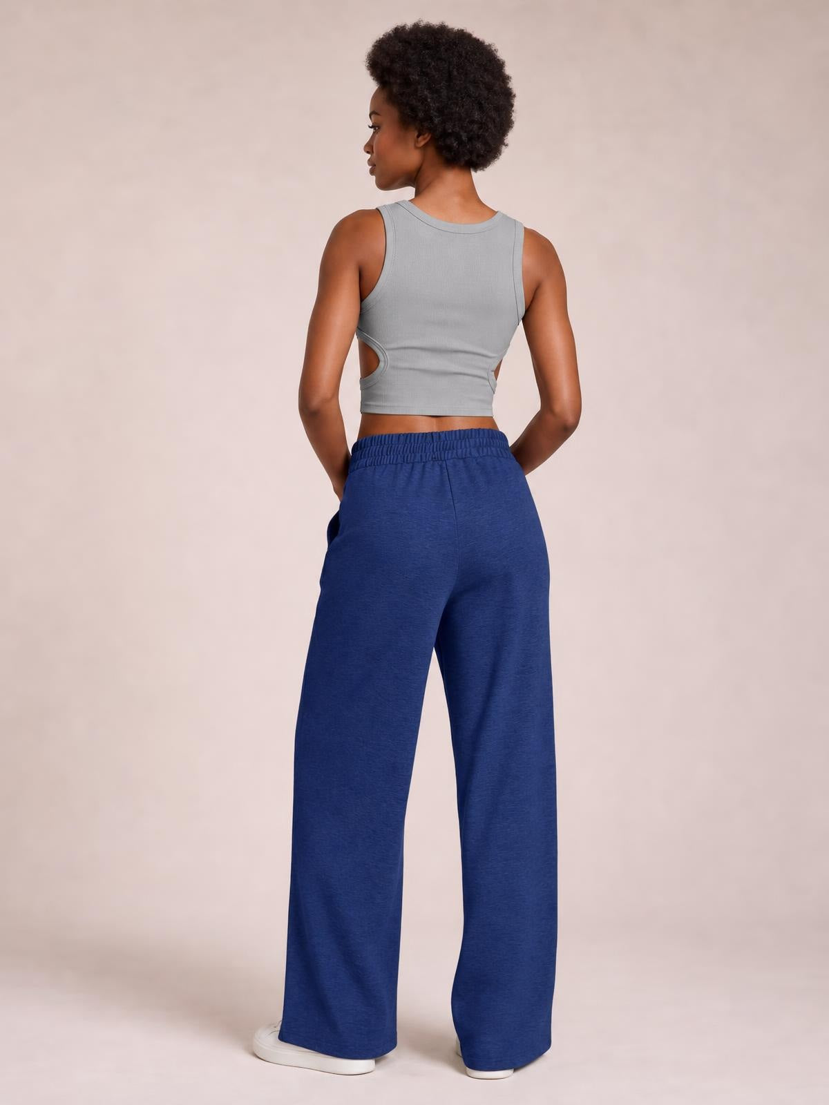 Model shown from behind wearing blue drawstring elastic waist wide leg pants with a relaxed, flowy silhouette and hands in the pockets.