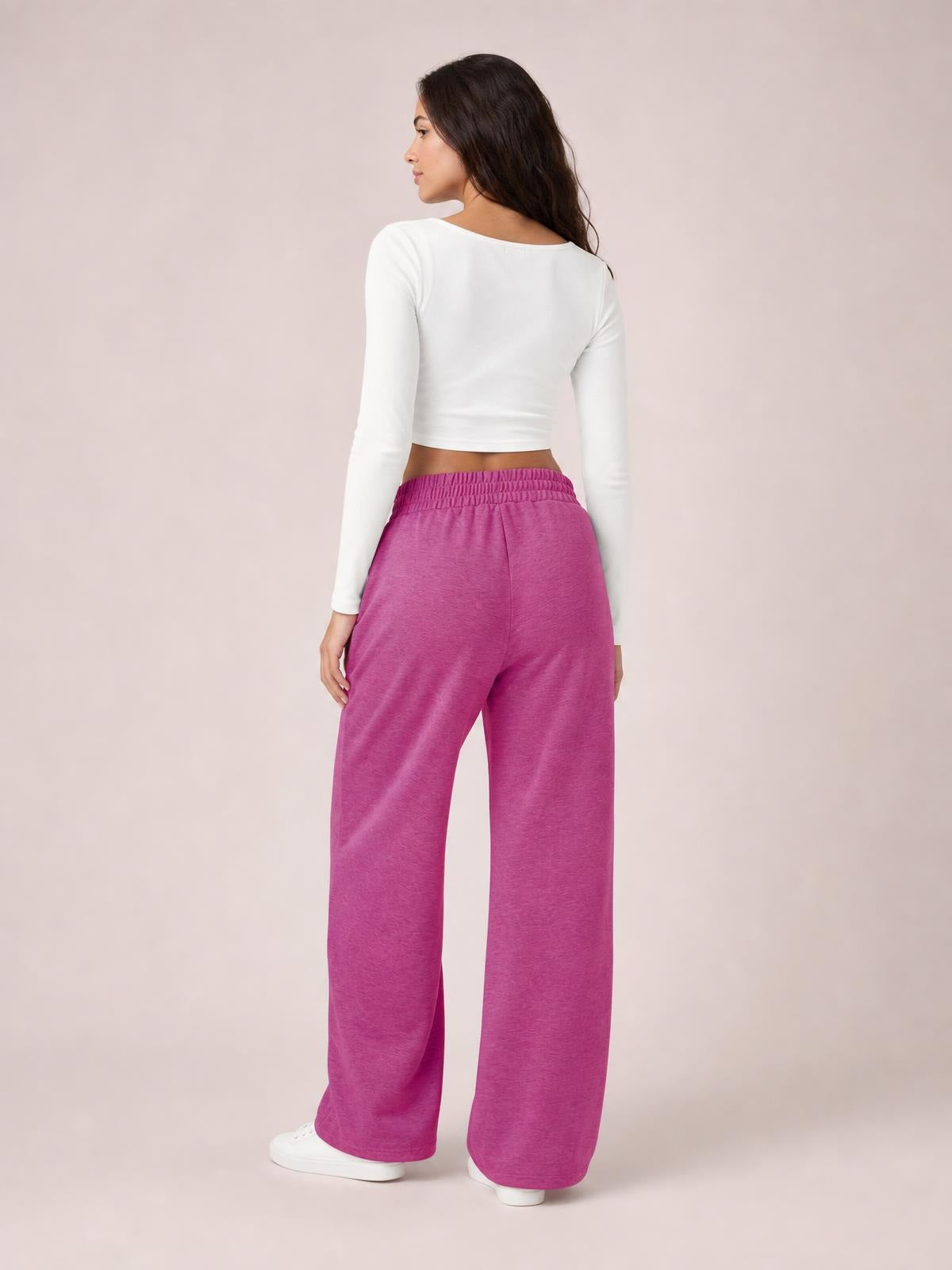 Model shown from the back wears magenta drawstring elastic-waist pants with a relaxed wide-leg silhouette and full-length hems.