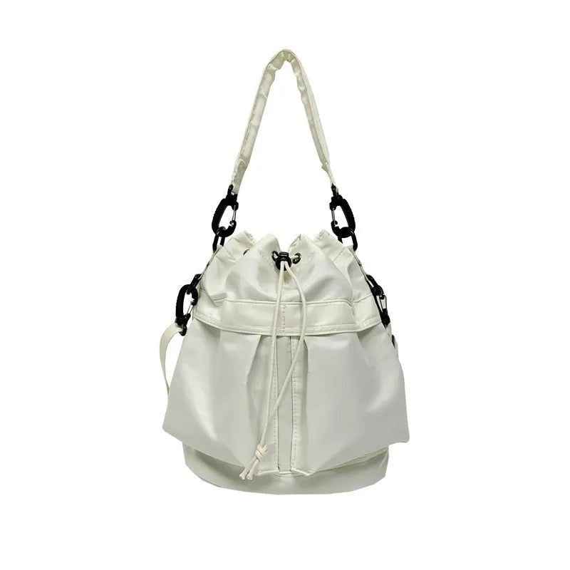 White medium nylon bucket bag with a softly gathered drawstring opening, relaxed silhouette, structured rounded base, and detachable shoulder straps with black hardware.