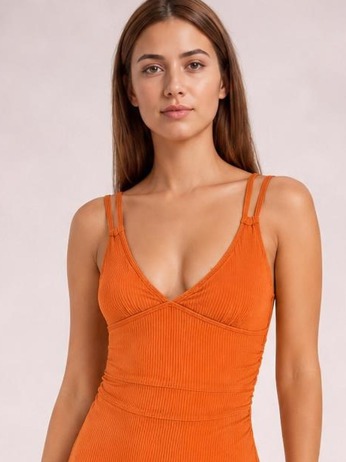 Front-facing model wears an orange drawstring plunge one-piece swimsuit with a ribbed texture, crossed bust panels, adjustable shoulder straps, and a fitted silhouette.