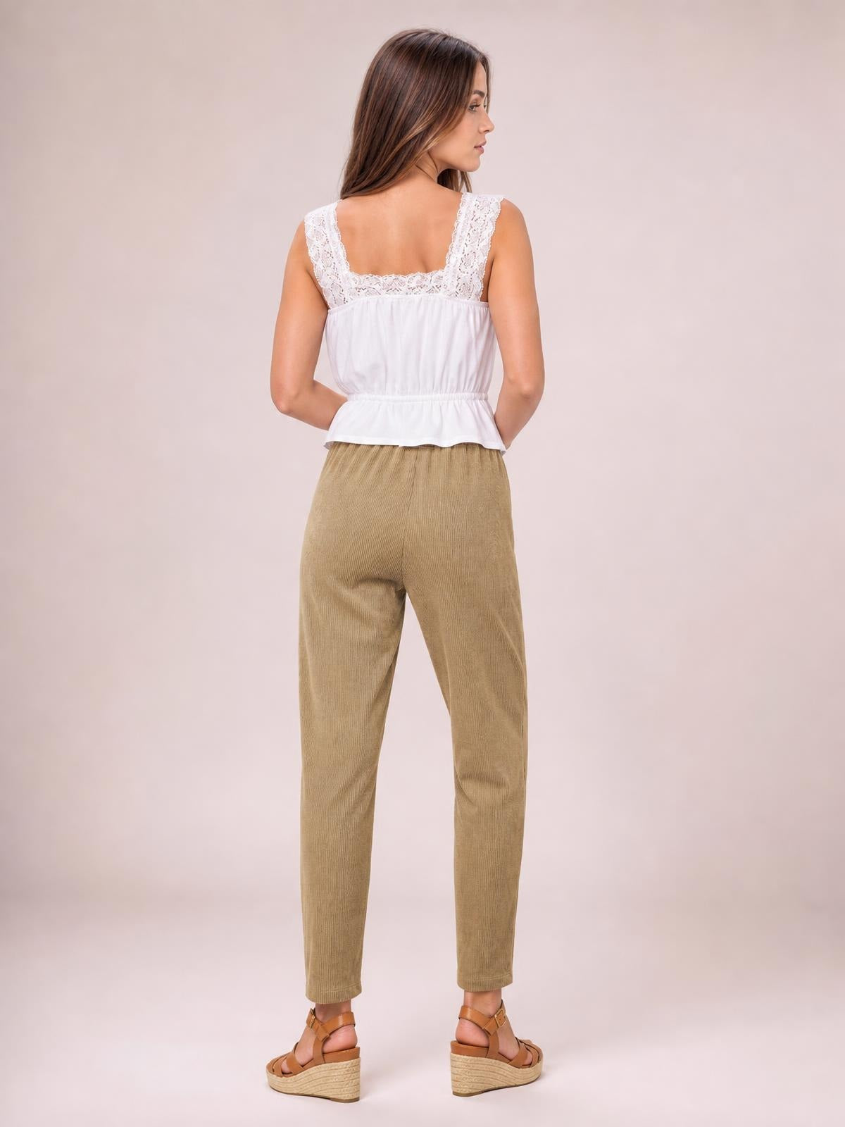 A model stands in a back view wearing tan drawstring straight pants with a comfortable waistband and slim, ankle-length silhouette.