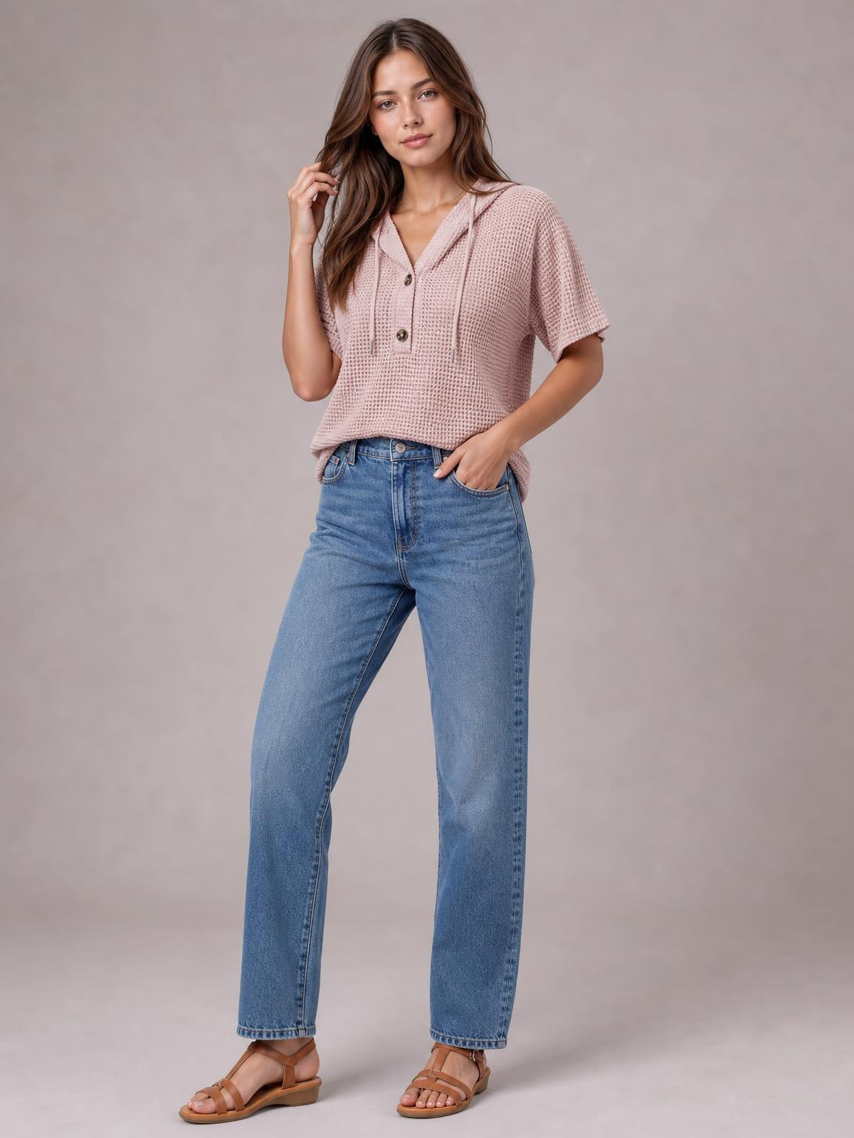 Model poses in a dusty pink waffle-knit short-sleeve hooded top with drawstrings, button placket, and a relaxed silhouette.