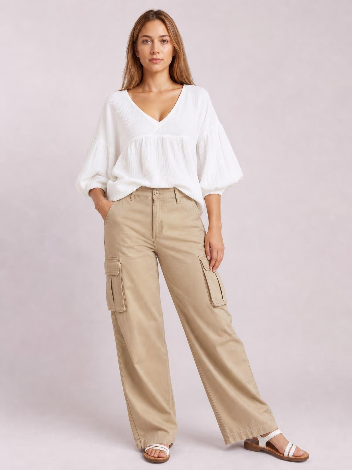 Model poses in a white solid V-neck blouse with dropped shoulders, long balloon sleeves, and a relaxed gathered silhouette.