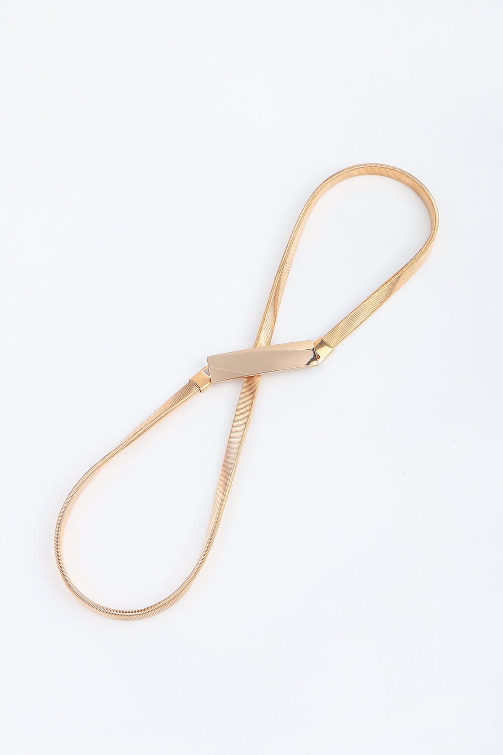 A slender elastic iron belt in a warm metallic tone features a structured rectangular buckle and flexible looped construction.
