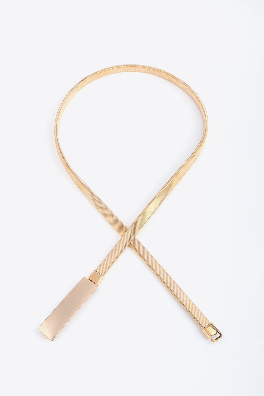 A gold-toned elastic iron skinny belt features a slender ribbed strap and sleek rectangular buckle for a polished waist-defining finish.