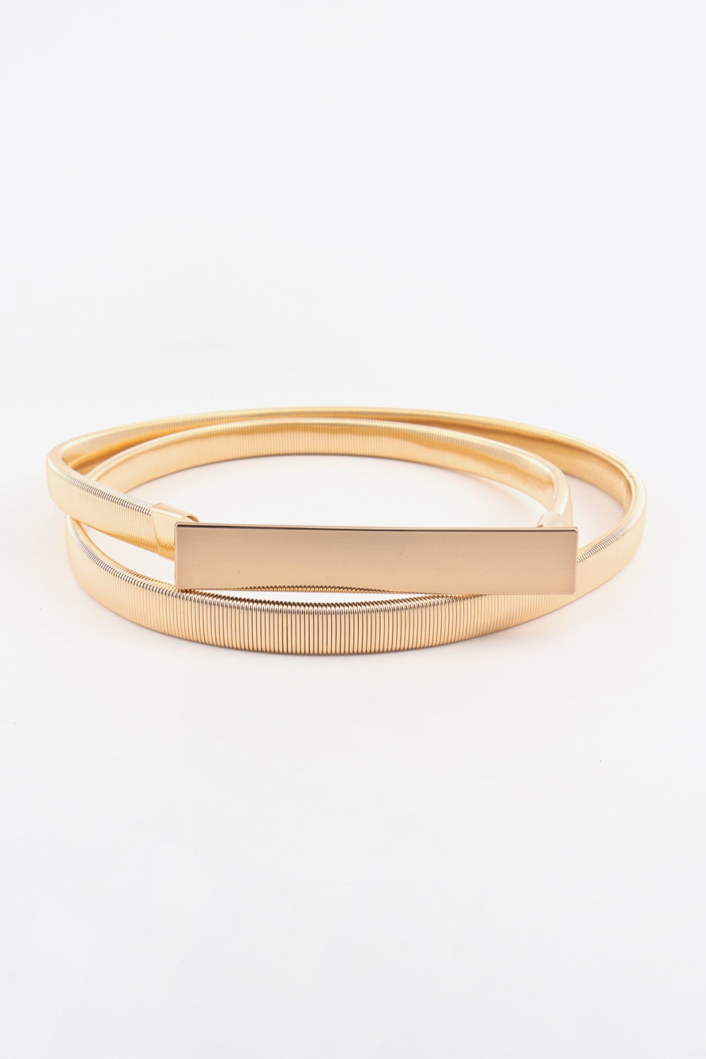 A sleek gold-tone elastic iron skinny belt features a finely ribbed band and a structured rectangular buckle for a polished waist-defining finish.