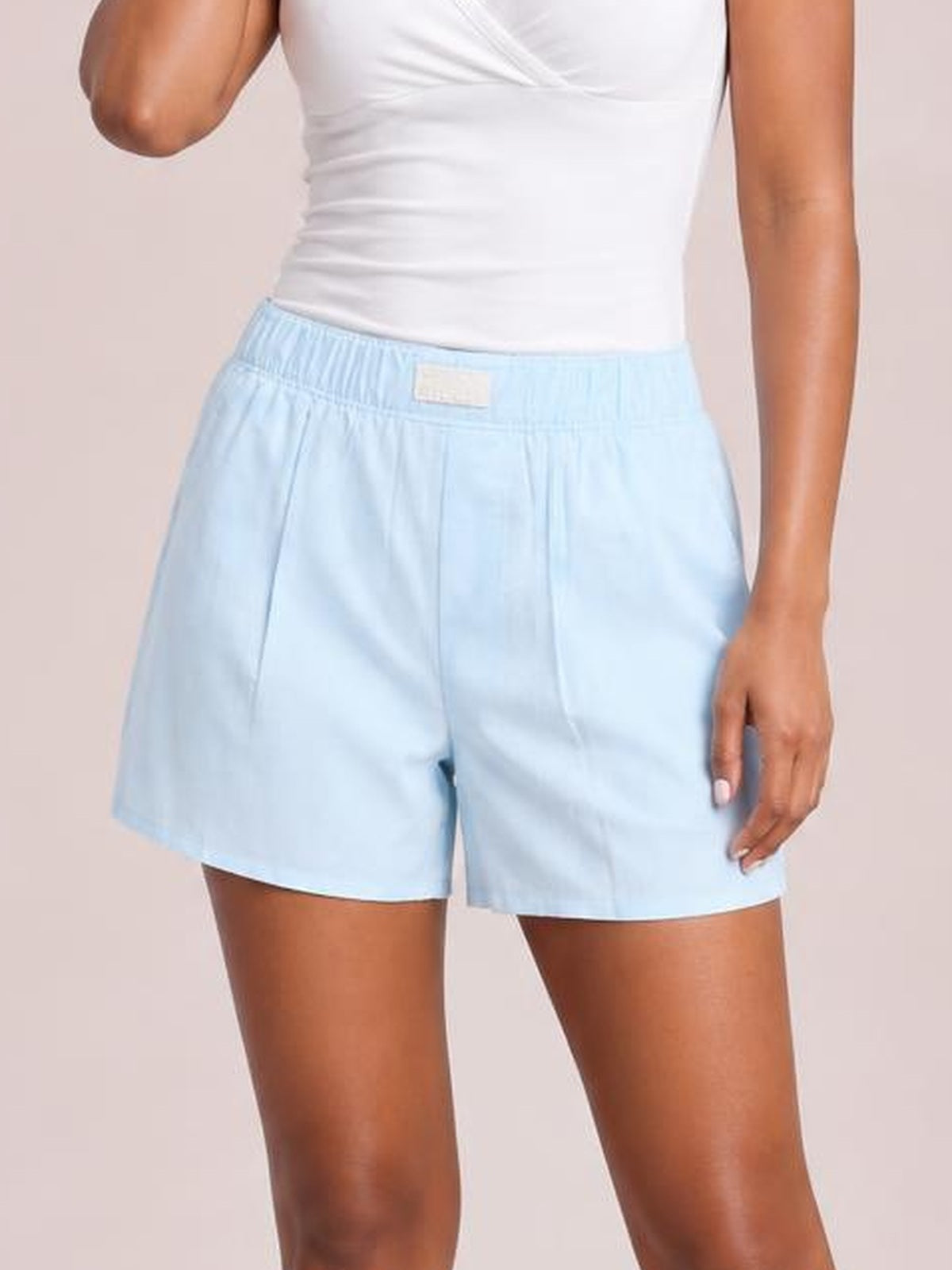 Model wearing light blue elastic waist shorts with a relaxed, straight silhouette, wide leg openings, and side pockets.