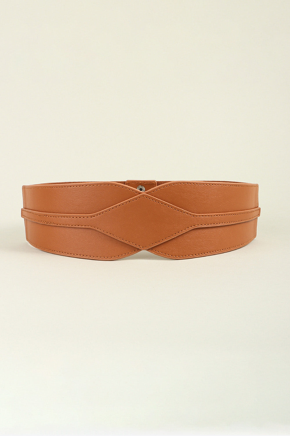 A wide caramel-brown PU belt with a sculptural contoured front, curved layered panels, neat topstitching, and a discreet snap fastening.