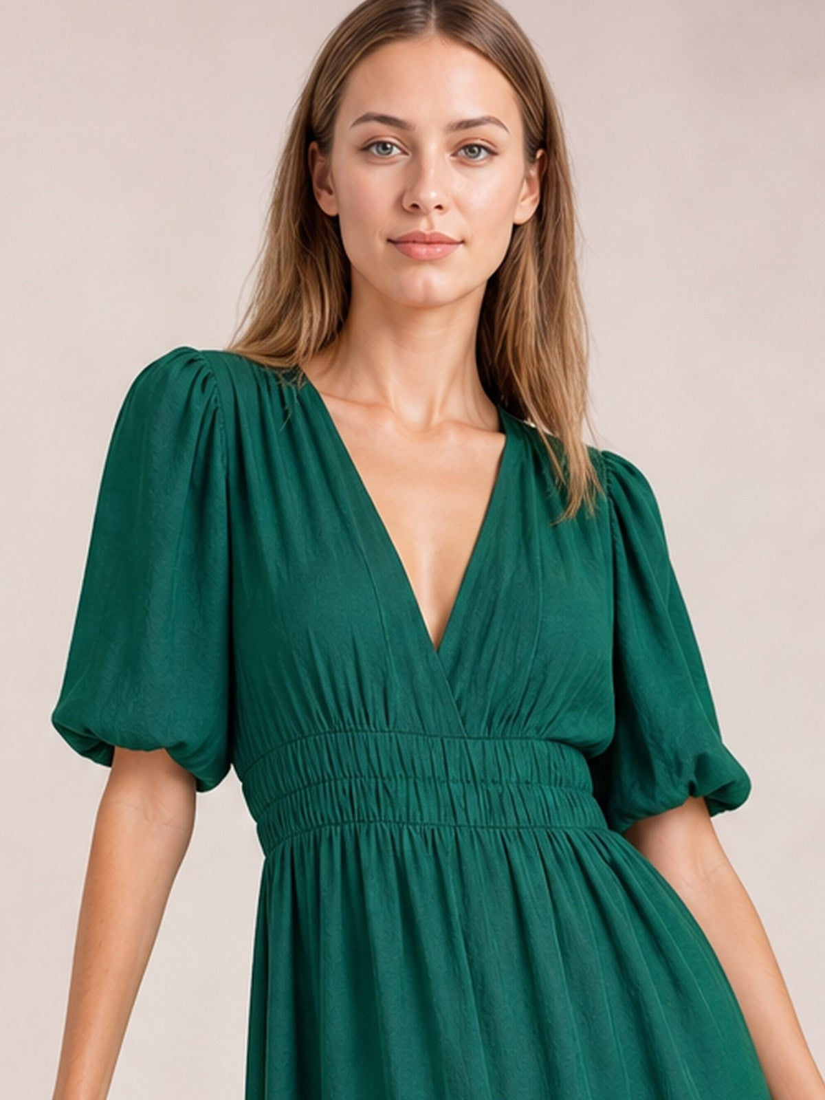 A model faces the camera in an elegant deep green V-neck midi dress with voluminous puff sleeves, a smocked waist, and a flowing tiered silhouette.