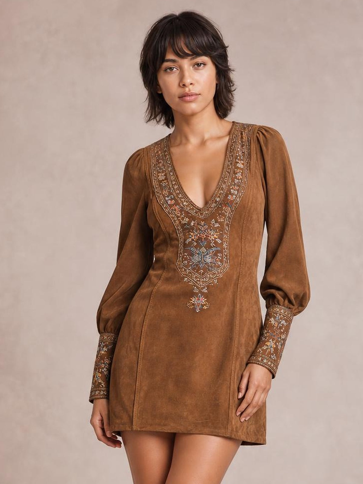 Model poses in a brown embroidered mini dress with a deep V-neck, relaxed straight silhouette, and long lantern sleeves with embellished cuffs.