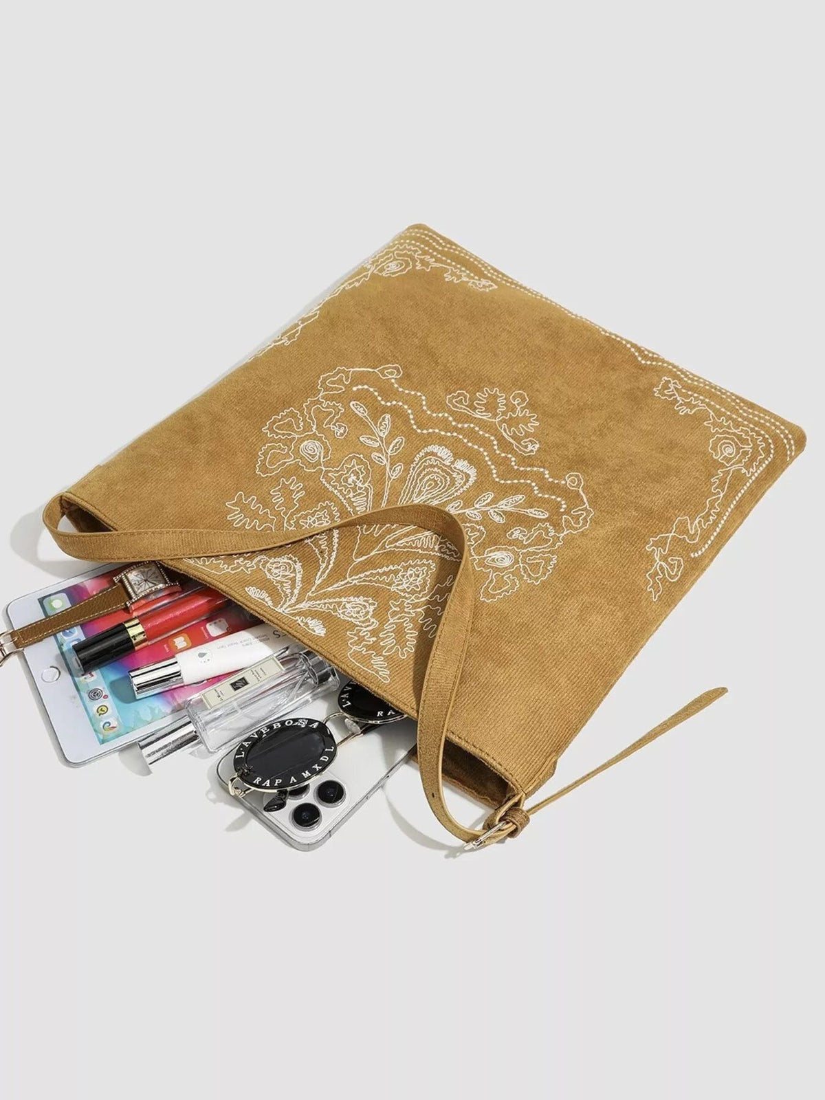 Large tan suede handbag with white embroidered floral and paisley motifs, a spacious open tote silhouette, and long flat shoulder straps.
