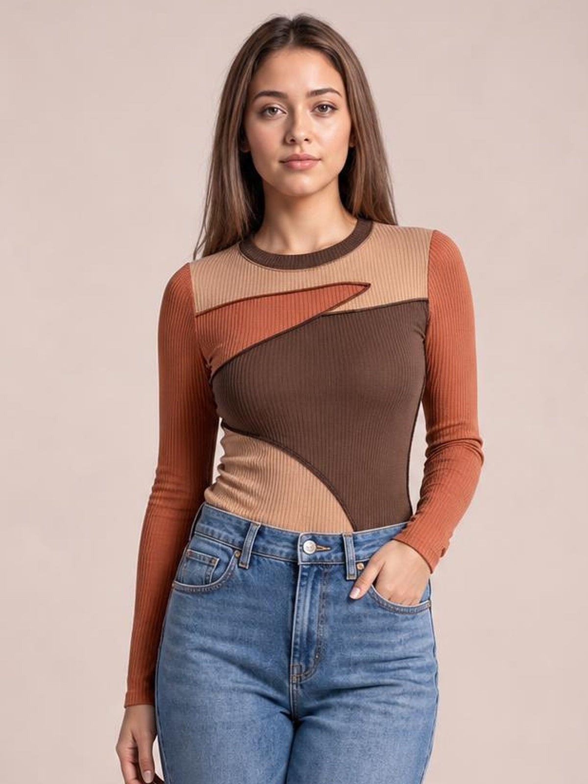 Model stands with one hand in her jeans pocket, wearing a fitted contrast long sleeve T-shirt with a round neck and exposed diagonal seams.
