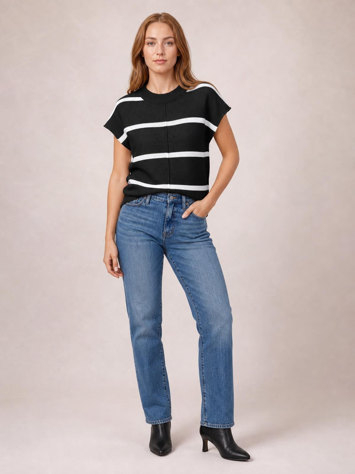 Model poses in a black round-neck knit top with contrasting white horizontal stripes, exposed center seam, short sleeves, and a relaxed silhouette.