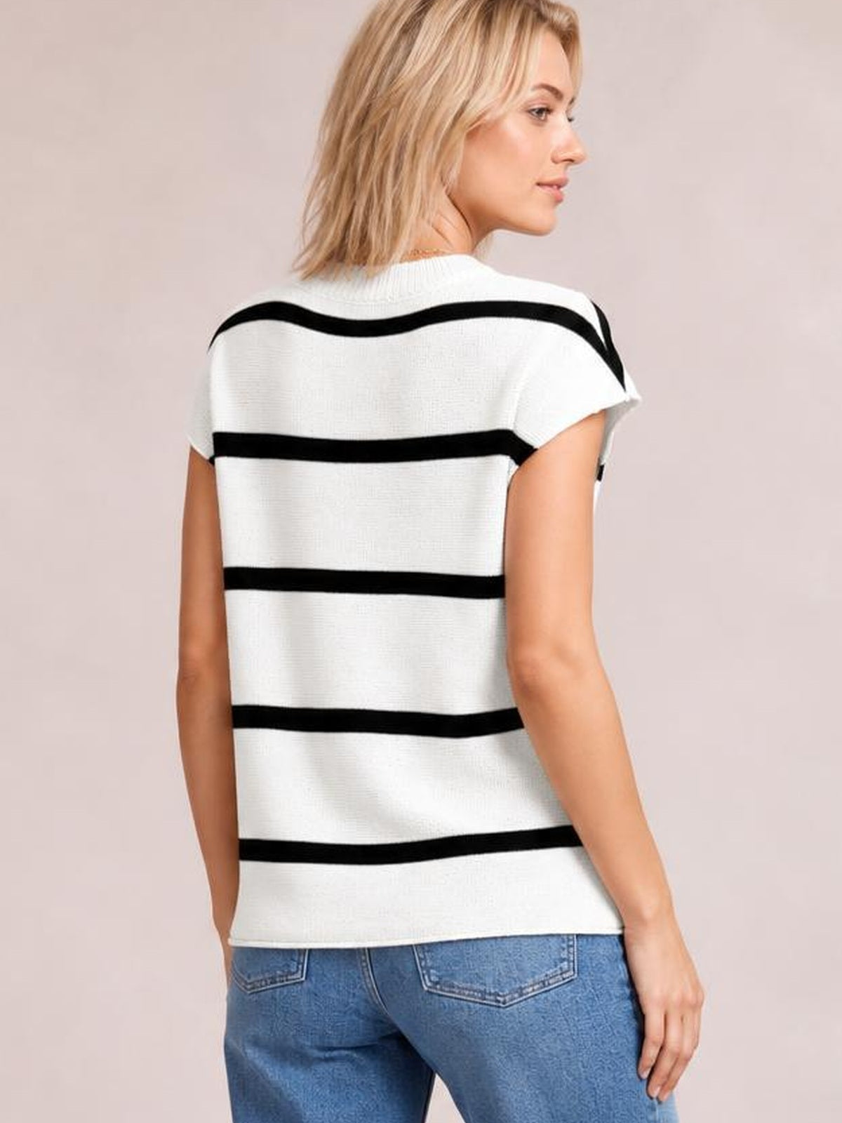 Model shown from the back in a white knit top with bold black horizontal stripes, round neckline, short sleeves, and a relaxed straight silhouette.