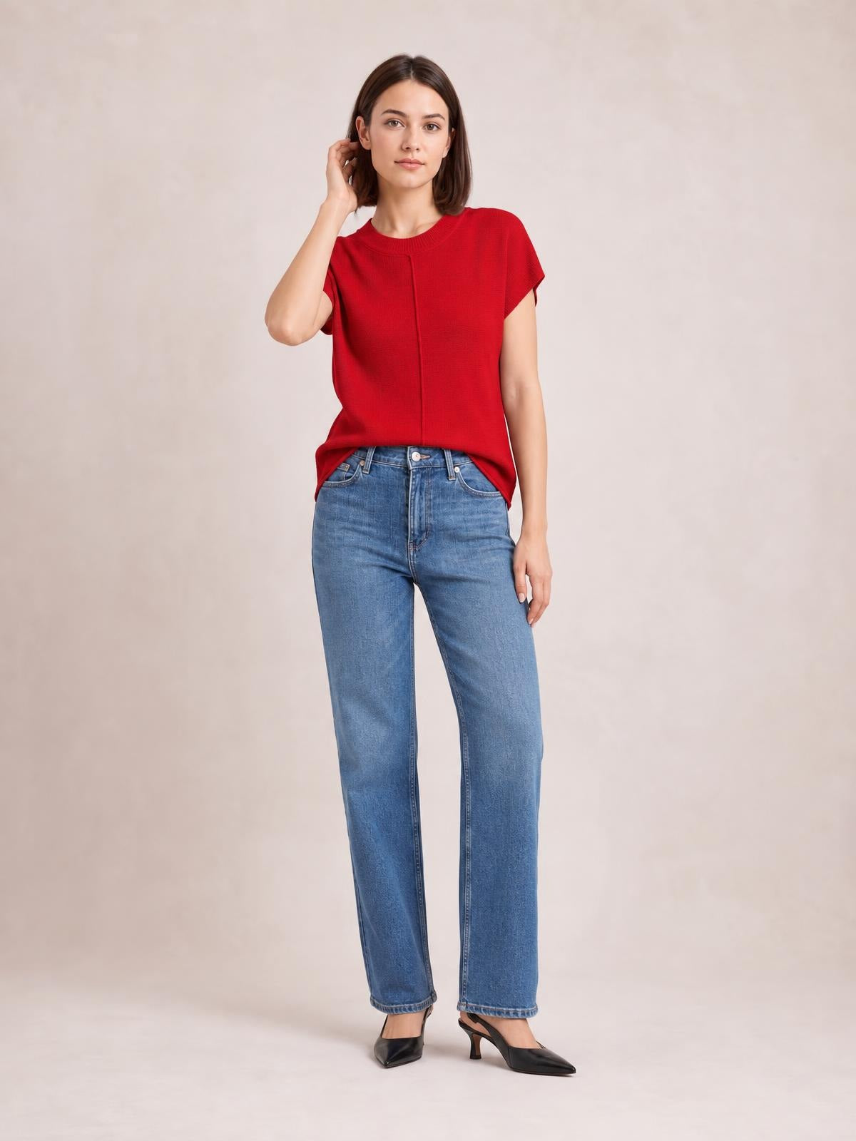 Model poses in a red exposed-seam round-neck short-sleeve sweater with a relaxed straight silhouette and slightly curved hem.