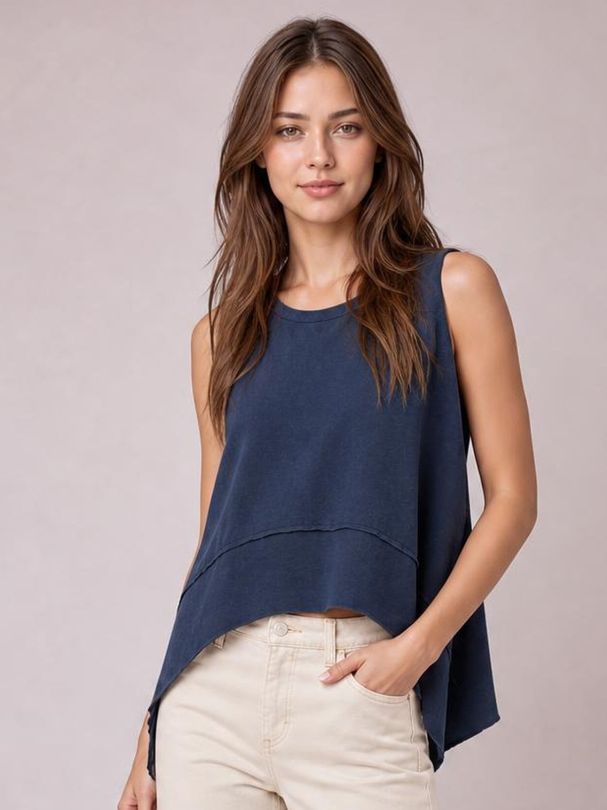 Model wearing a navy round neck tank with exposed seams, slightly stretchy fabric, a relaxed silhouette, and long side slits.