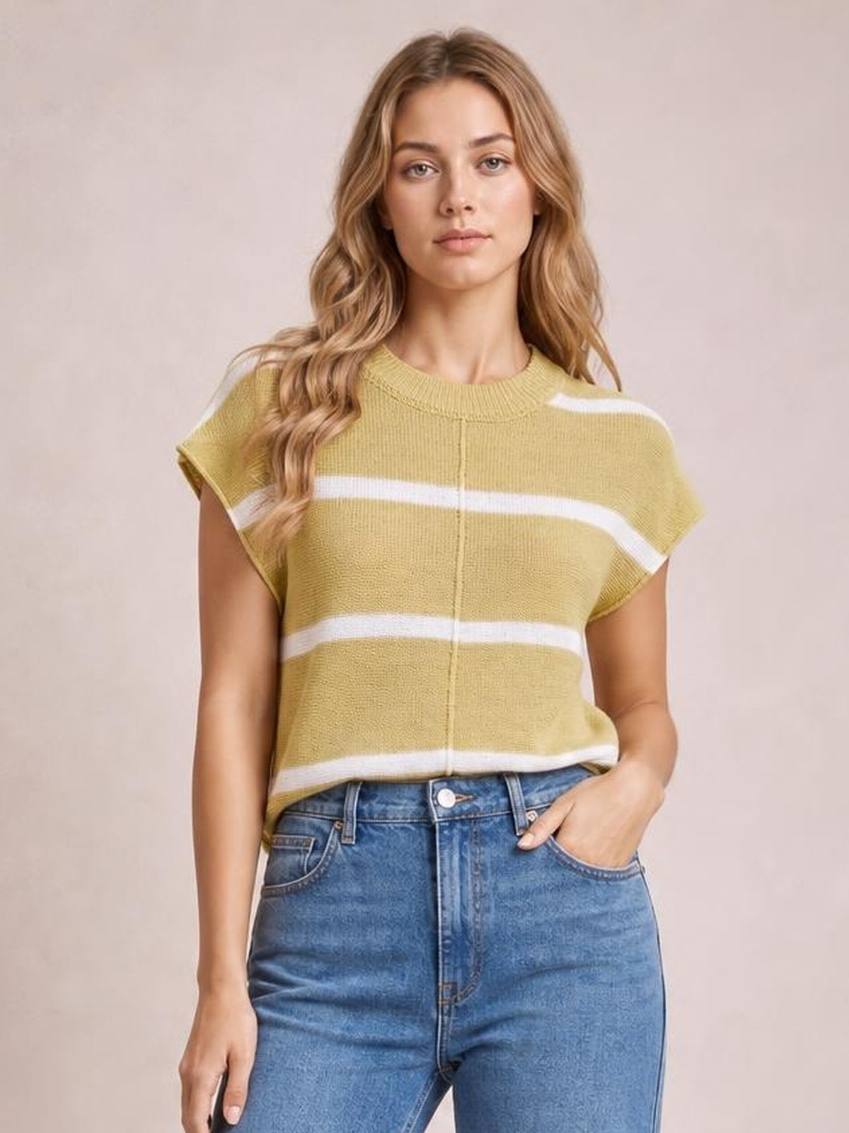 Model wears an olive green striped knit top with a round neck, exposed center seam, short sleeves, relaxed silhouette, and one hand in her jeans pocket.