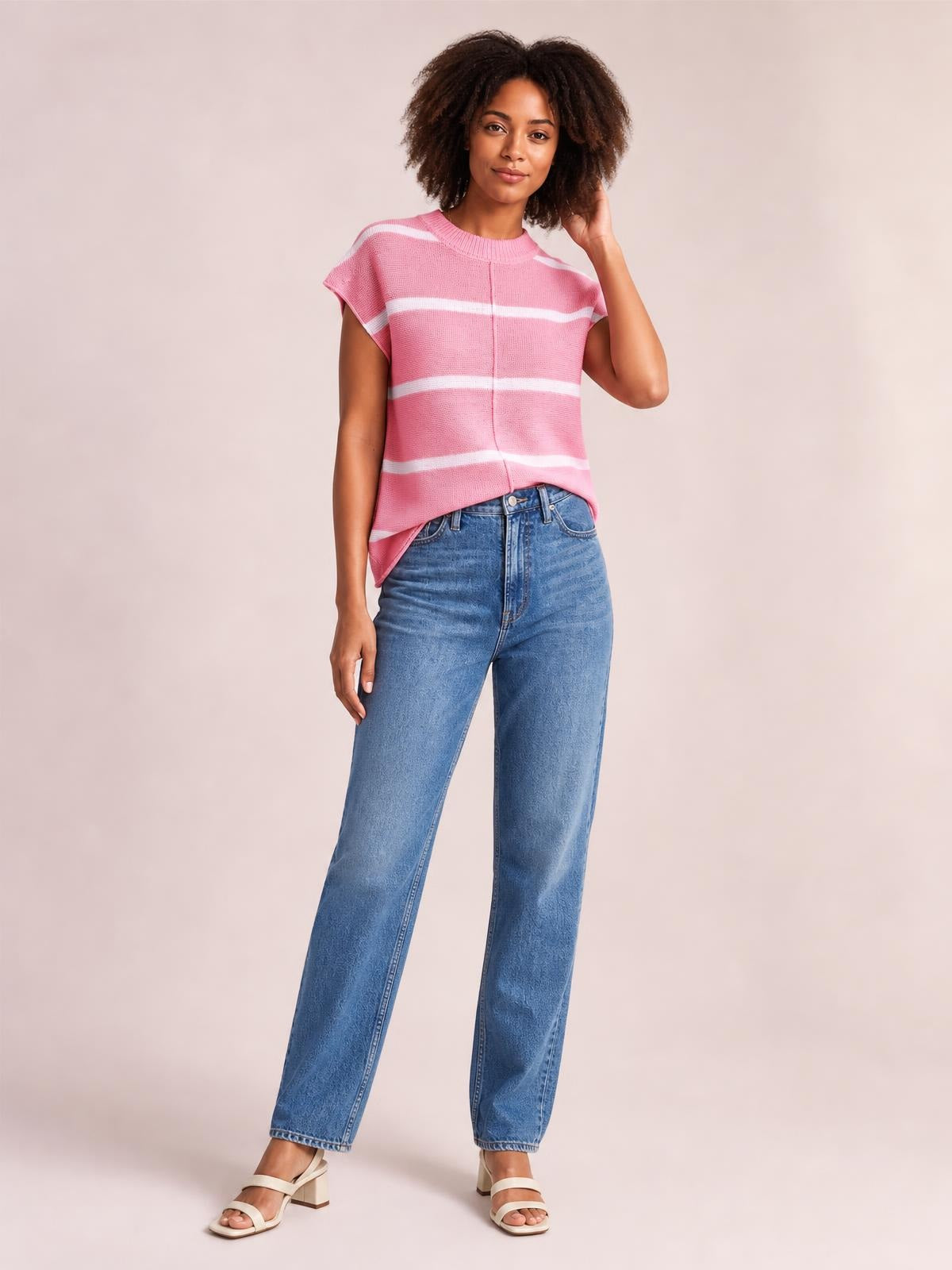 Model poses in a pink striped round-neck knit top with exposed center seam, short sleeves, and a relaxed straight silhouette.