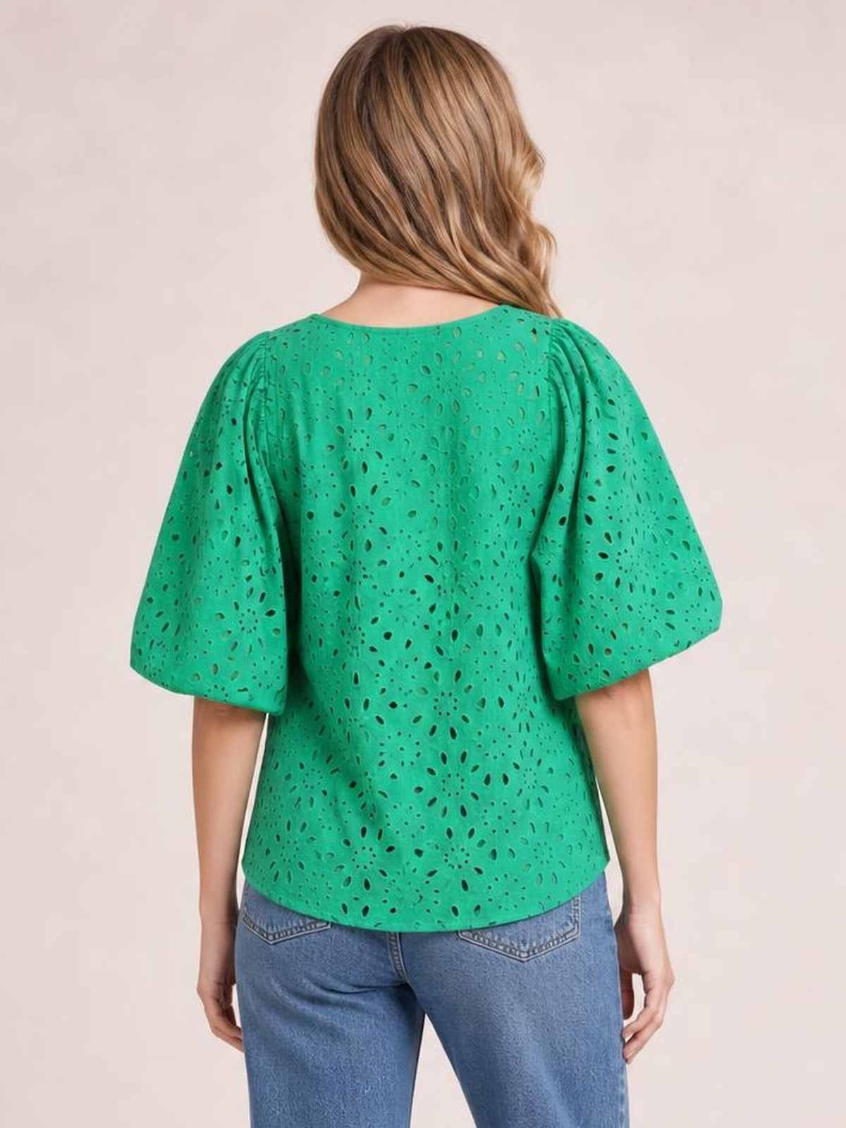 Model shown from behind wearing a bright green eyelet blouse with loose half sleeves, a rounded neckline, and a relaxed, straight silhouette.