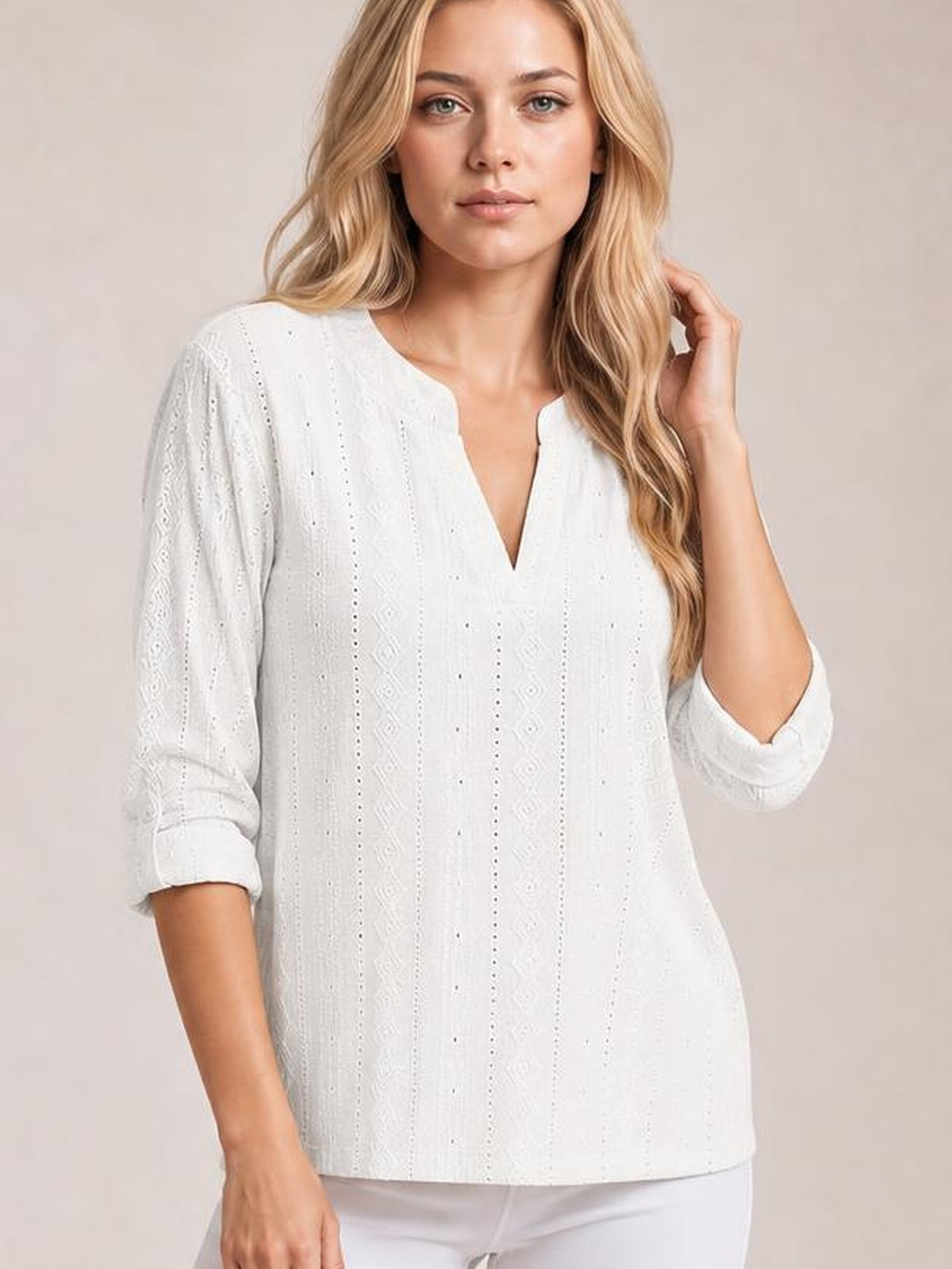 Model wears a white eyelet top with a notched V-neckline, rolled-tab three-quarter sleeves, and a relaxed straight silhouette.