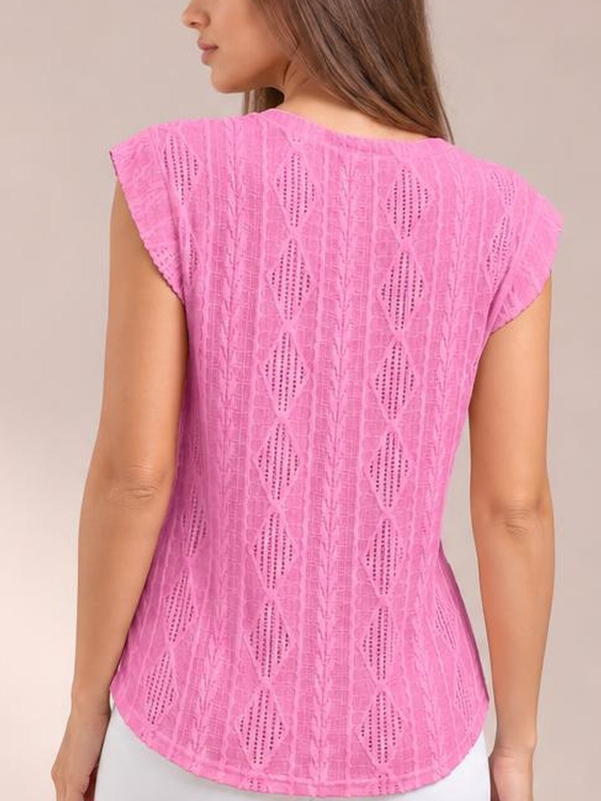 A model wears a bright pink eyelet top with a round neckline, cap sleeves, relaxed straight silhouette, and curved hem, shown from the back.