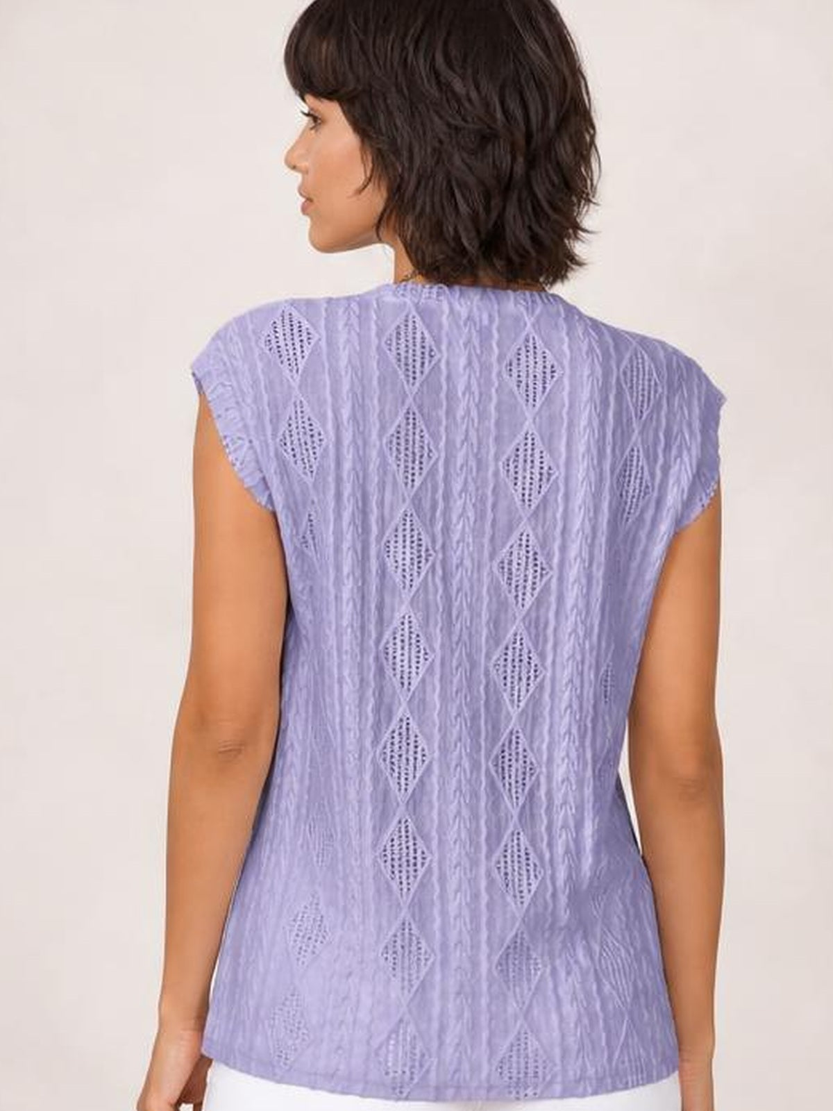 Model shown from behind wearing a lilac eyelet round neck cap sleeve top with a relaxed straight silhouette and diamond-pattern construction.