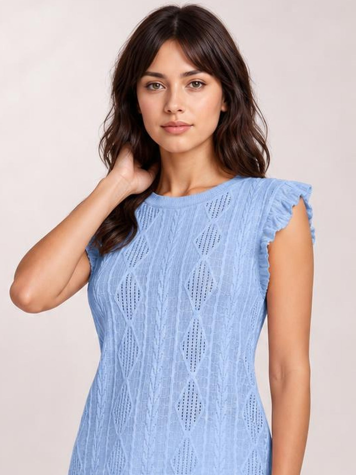 Model wearing a light blue eyelet round neck cap sleeve top with a fitted silhouette and textured diamond cutout pattern, posing with one hand behind her neck.