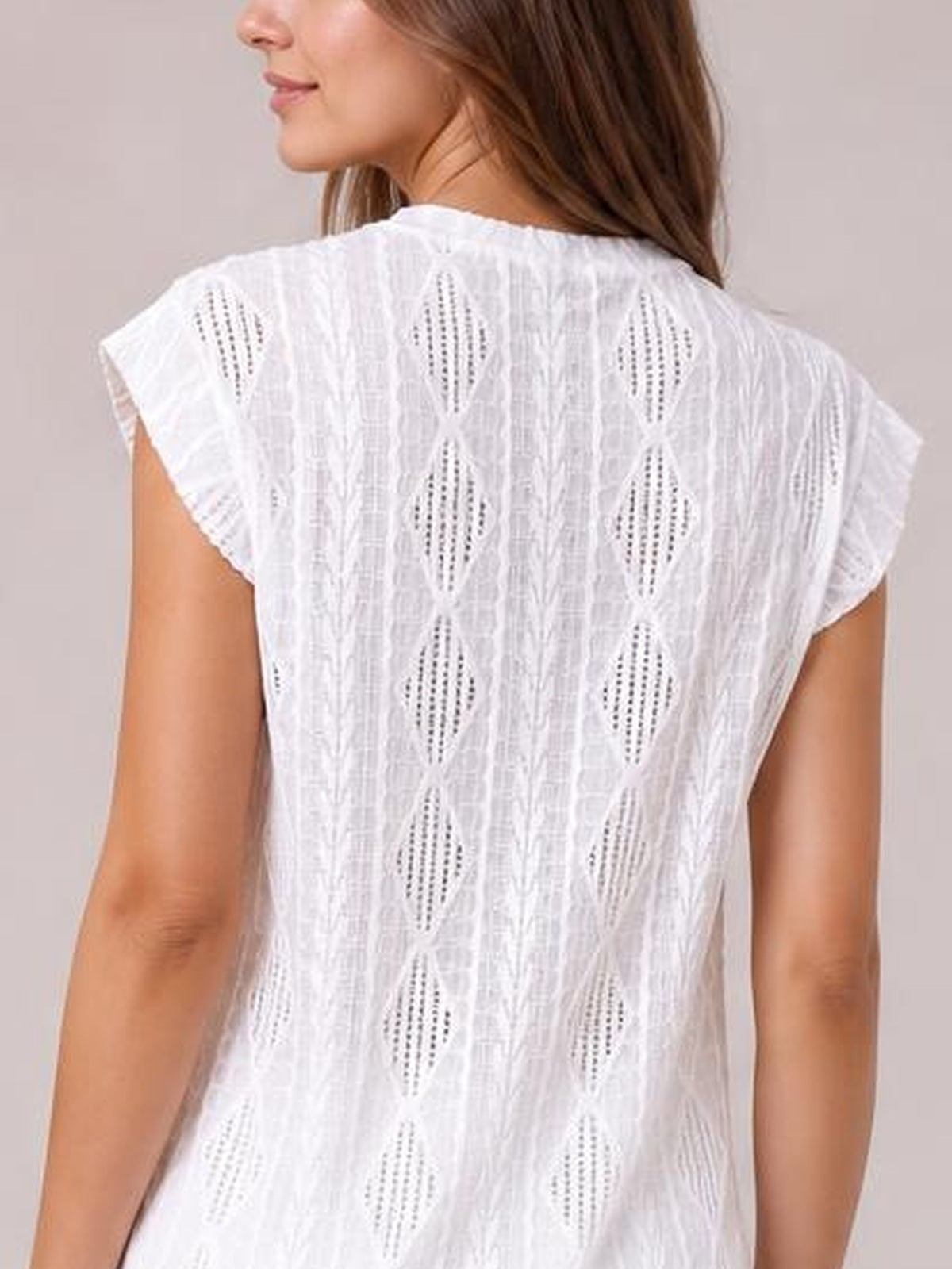 Model shown from the back wearing a white eyelet top with a round neck, cap sleeves, diamond-pattern details, and a relaxed straight silhouette.