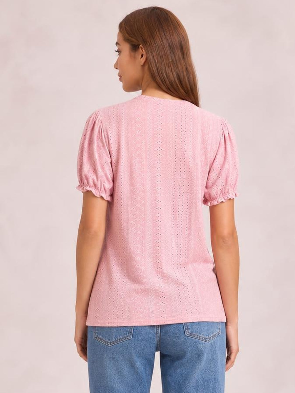 Model shown from behind wearing a pink eyelet blouse with a round neck, short puff sleeves with delicate frill trim, and a relaxed straight silhouette.
