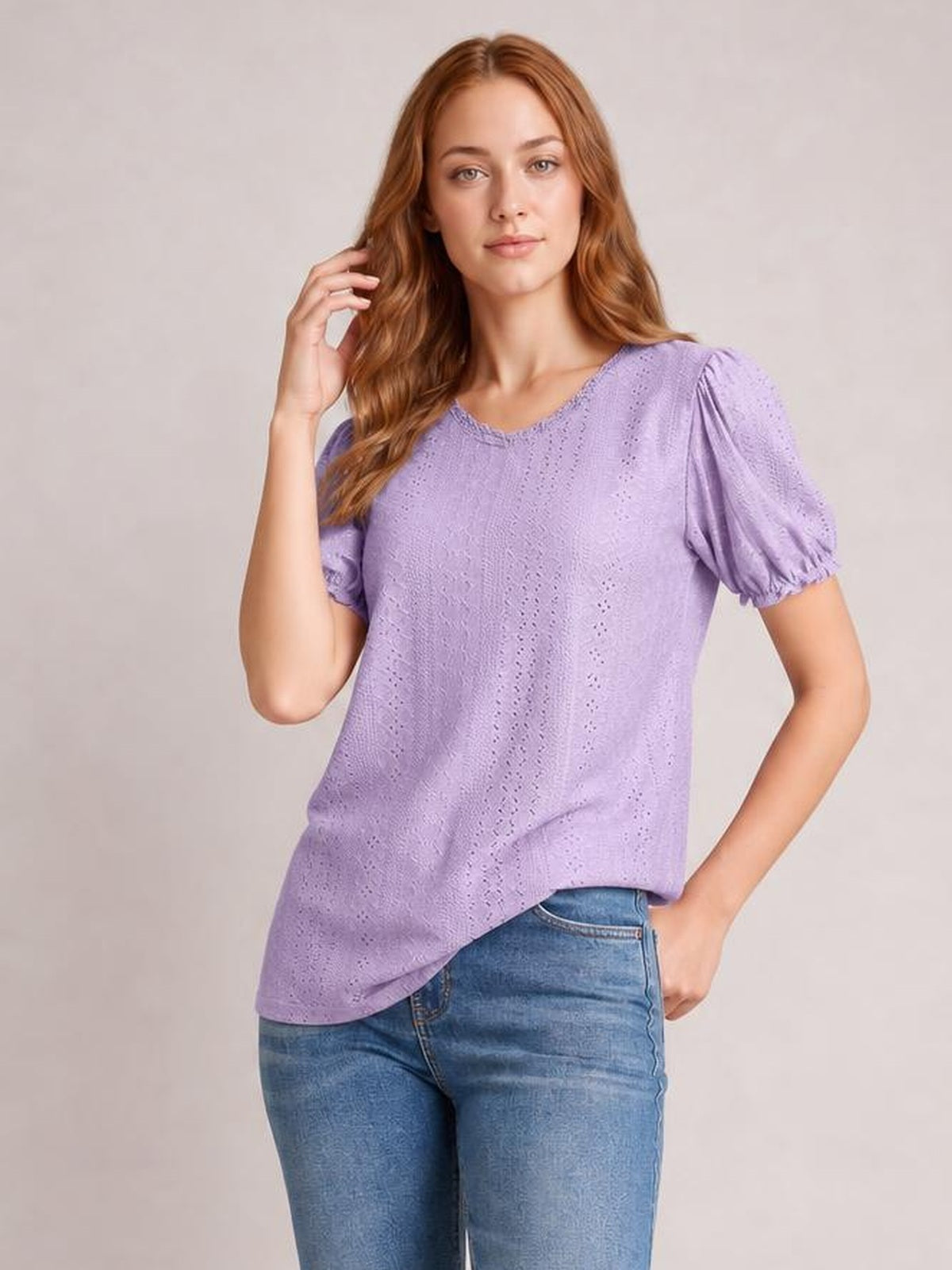 Model poses in a lavender eyelet blouse with a round neck, delicate frill, short puff sleeves, and a relaxed silhouette.
